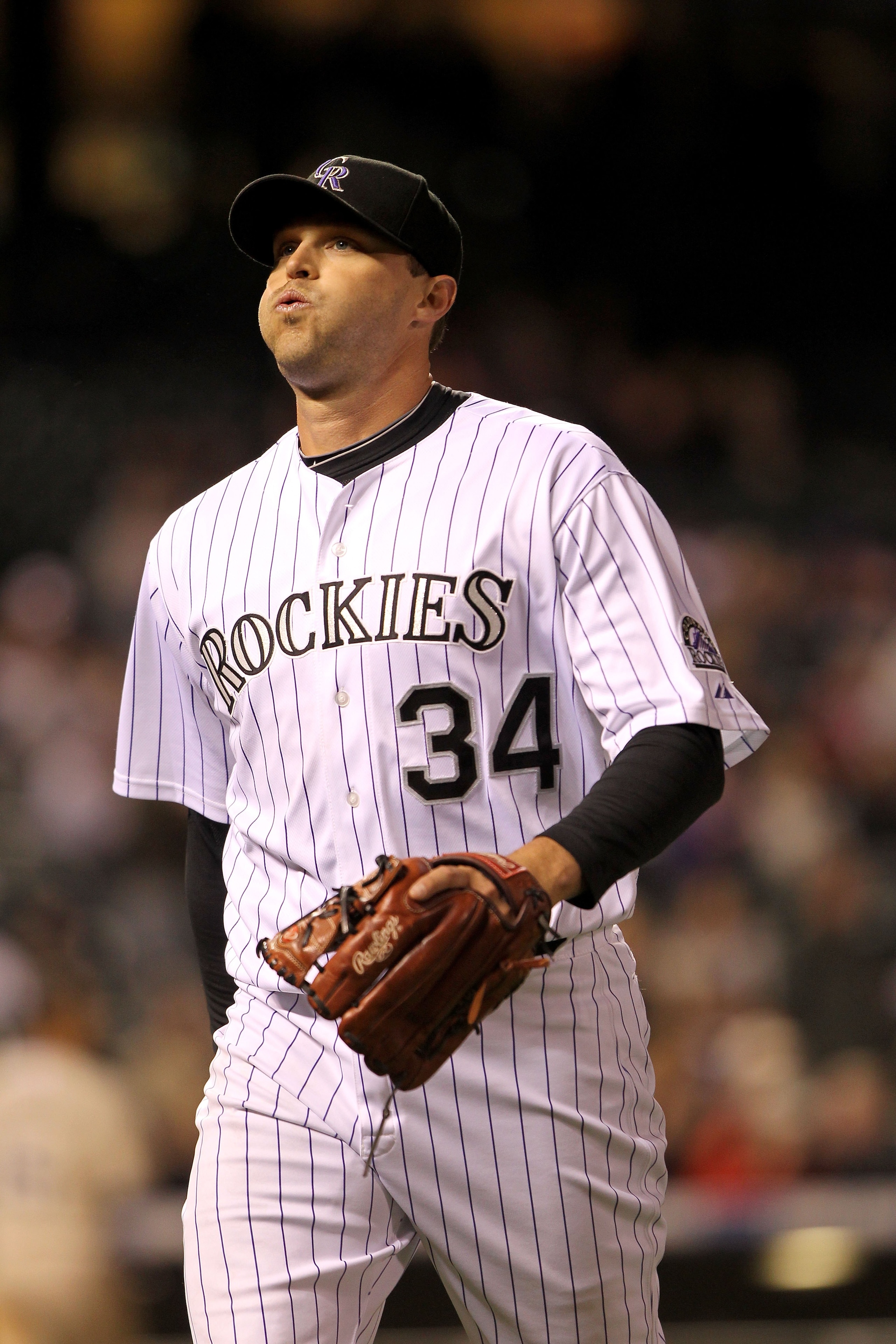 DENVER - APRIL 10:  Relief pitcher Matt Belisle #34 of the Colorado Rockies breathes easy after leaving the mound and heading for the dugout after escaping a tight spot against the San Diego Padres during MLB action at Coors Field on April 10, 2010 in Den