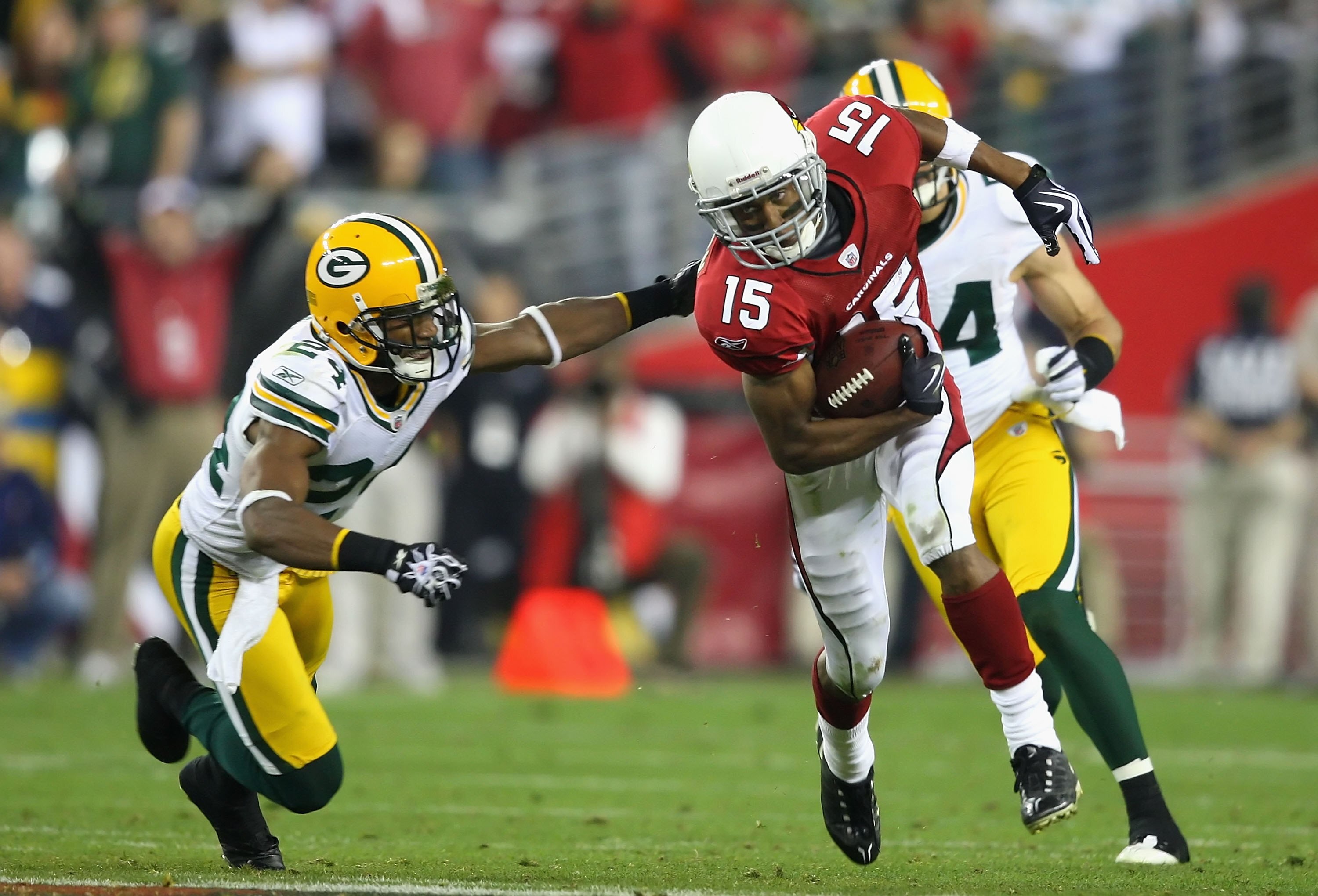GLENDALE, AZ - JANUARY 10:  Wide receiver Steve Breaston #15 of the Arizona Cardinals runs with the ball past Jarrett Bush #24 of the Green Bay Packers during the 2010 NFC wild-card playoff game at the Universtity of Phoenix Stadium on January 10, 2010 in