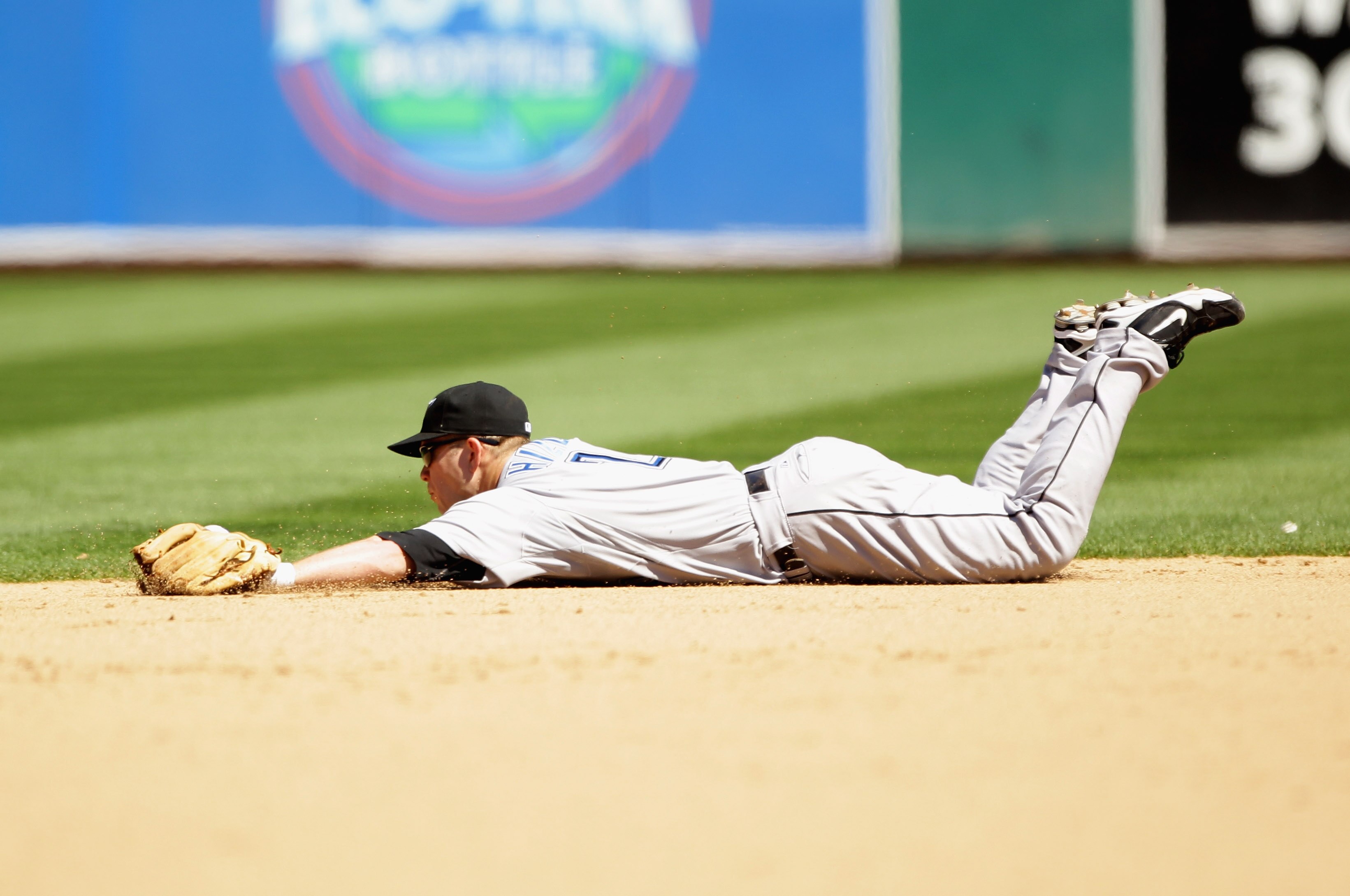OAKLAND, CA - AUGUST 18:  Aaron Hill #2 of the Toronto Blue Jays makes a diving stop on a ball hit by Mark Ellis #14 of the Oakland Athletics in the eighth inning at the Oakland-Alameda County Coliseum on August 18, 2010 in Oakland, California.  (Photo by