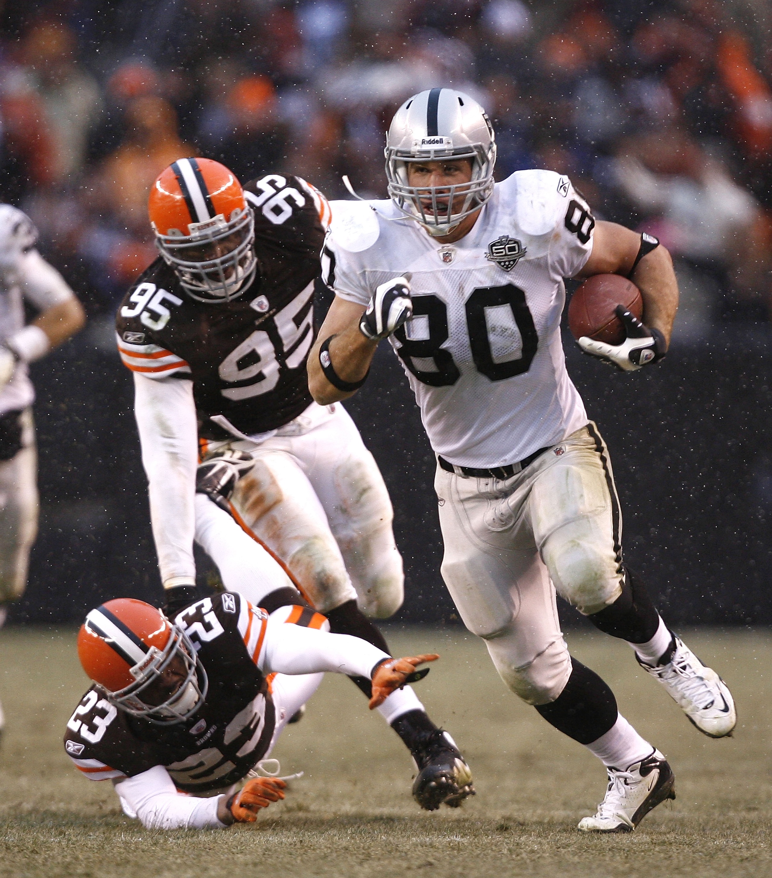 CLEVELAND - DECEMBER 27:  Zach Miller #80 of the Oakland Raiders runs by Hank Poteat #23 and Kamerion Wimbley #95 of the Cleveland Browns at Cleveland Browns Stadium on December 27, 2009 in Cleveland, Ohio.  (Photo by Matt Sullivan/Getty Images)