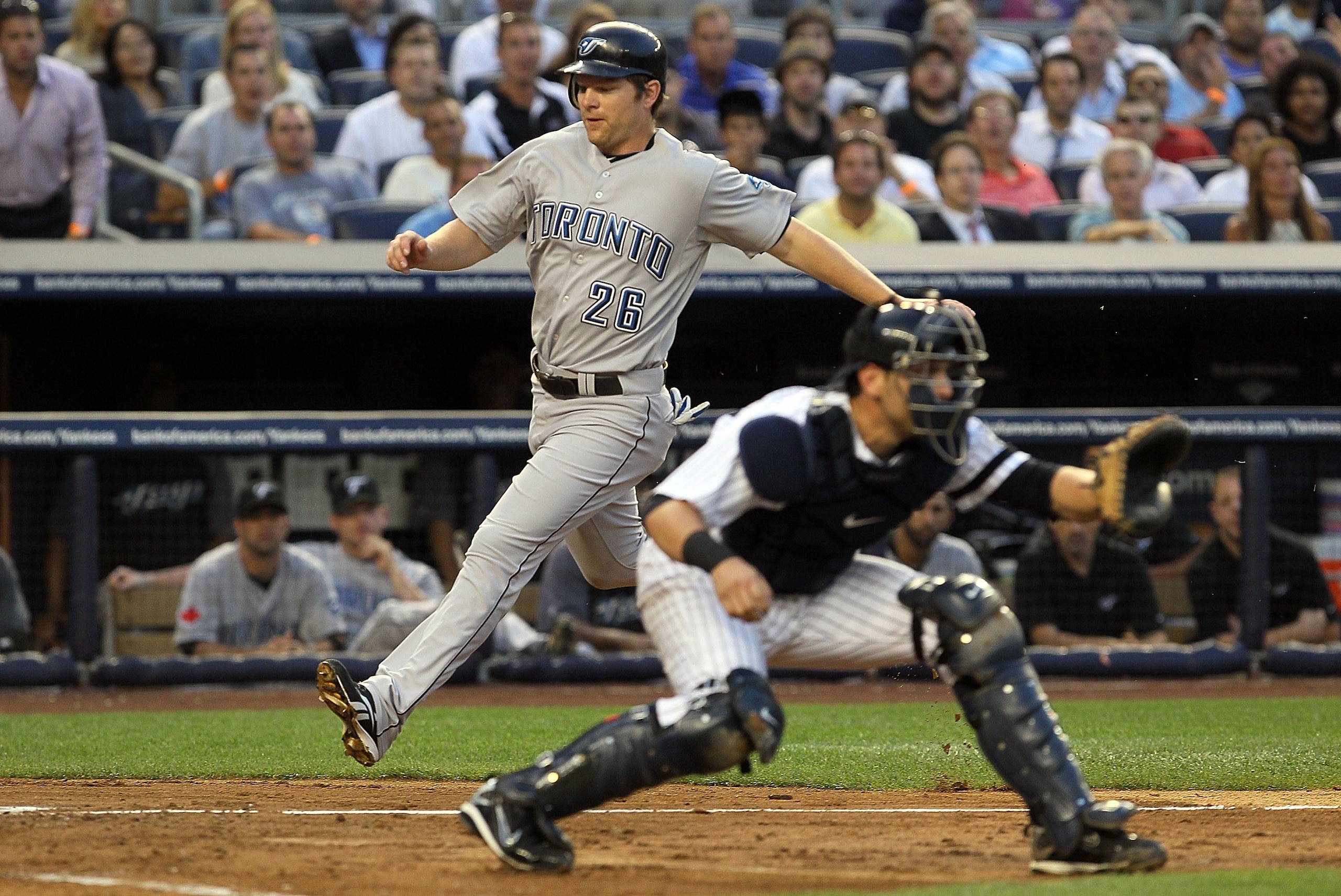 NEW YORK - AUGUST 03:  Adam Lind #26 of the Toronto Blue Jays scores a second inning run as Francisco Cervelli #29 of the New York Yankees waits for the ball on August 3, 2010 at Yankee Stadium in the Bronx borough of New York City.  (Photo by Jim McIsaac