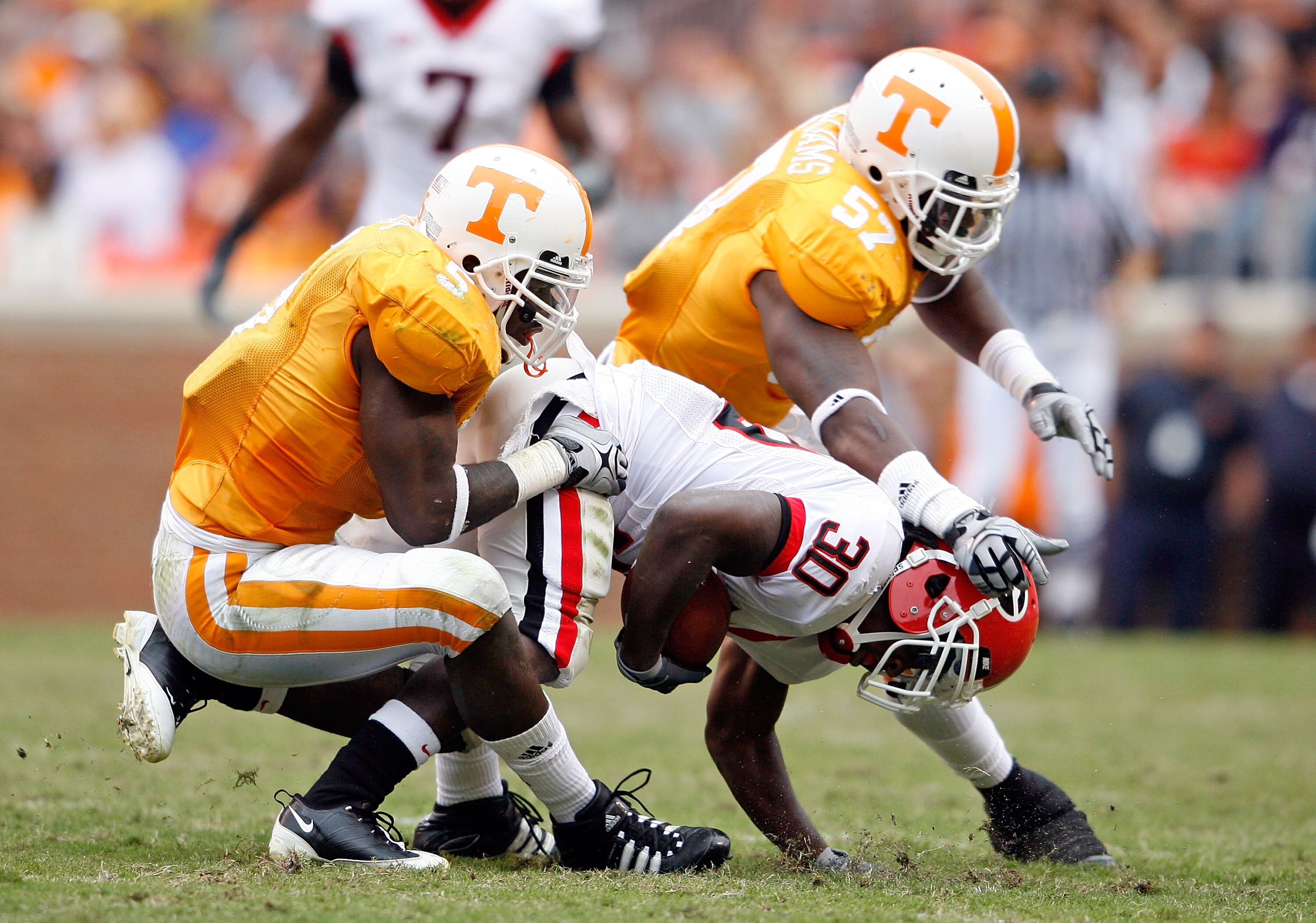 KNOXVILLE, TN - OCTOBER 10: Rico McCoy #5 and Gerald Williams #57 of the Tennessee Volunteers tackle Carlton Thomas #30 of the Georgia Bulldogs during the SEC game at Neyland Stadium on October 10, 2009 in Knoxville, Tennessee. (Photo by Andy Lyons/Getty