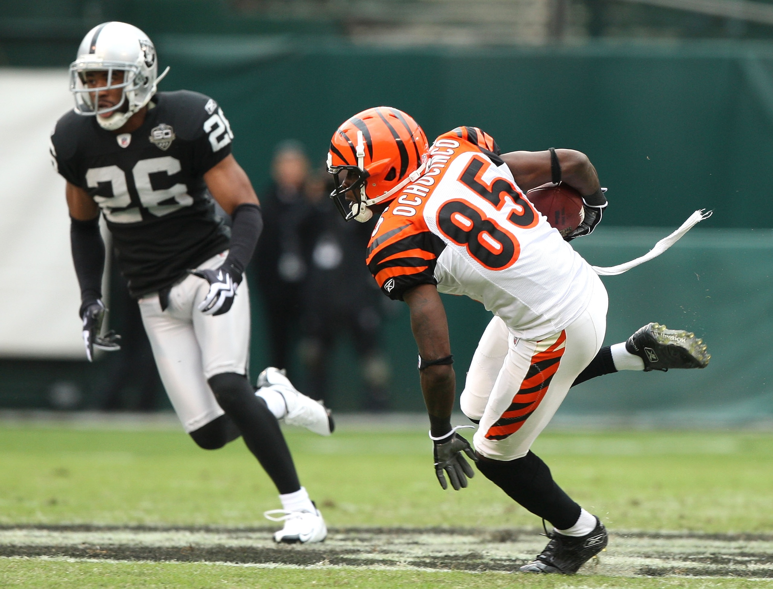 OAKLAND, CA - NOVEMBER 22:  Chad Ochocinco #85 of the Cincinnati Bengals runs after a catch against Stanford Routt #26 of the Oakland Raiders during an NFL game at Oakland-Alameda County Coliseum on November 22, 2009 in Oakland, California.  (Photo by Jed