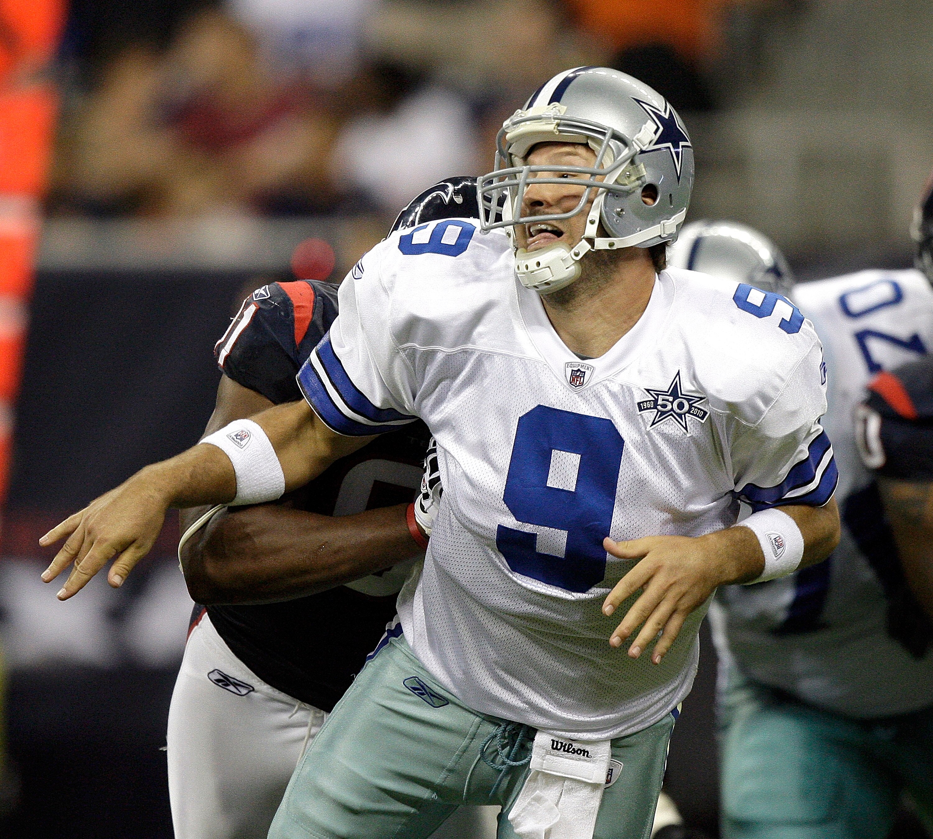 HOUSTON - AUGUST 28: Quarterback Tony Romo #9 of the Dallas Cowboys is hit from behind as he let's the ball go during a football game against the Houston Texans at Reliant Stadium on August 28, 2010 in Houston, Texas. Houston won 23-7. (Photo by Bob Levey