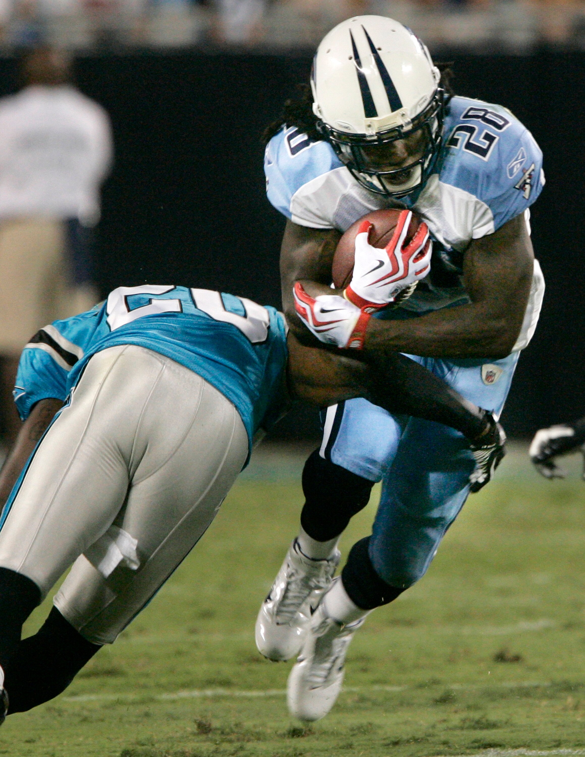 CHARLOTTE, NC - AUGUST 28:  Runningback Chris Johnson #28 of the Tennessee Titans is tackled by Chris Gamble #20 of the Carolina Panthers during their preseason game at Bank of America Stadium on August 28, 2010 in Charlotte, North Carolina. (Photo by Mar