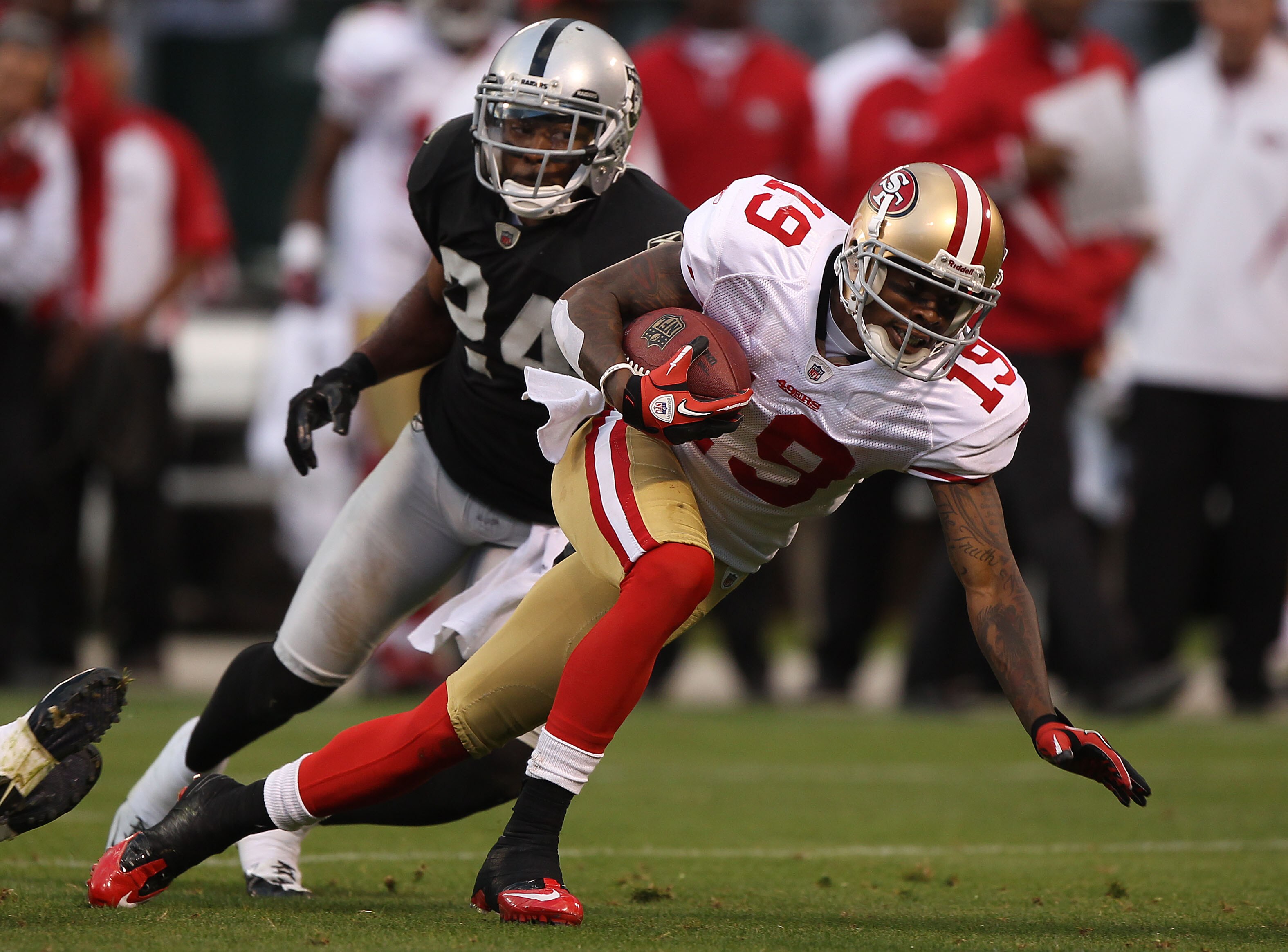 OAKLAND, CA - AUGUST 28: Ted Ginn #19 of the San Francisco 49er runs after a catch against Michael Huff #24 of the Oakland Raiders during an NFL preseason game at Oakland-Alameda County Coliseum on August 28, 2010 in Oakland, California. (Photo by Jed Jac