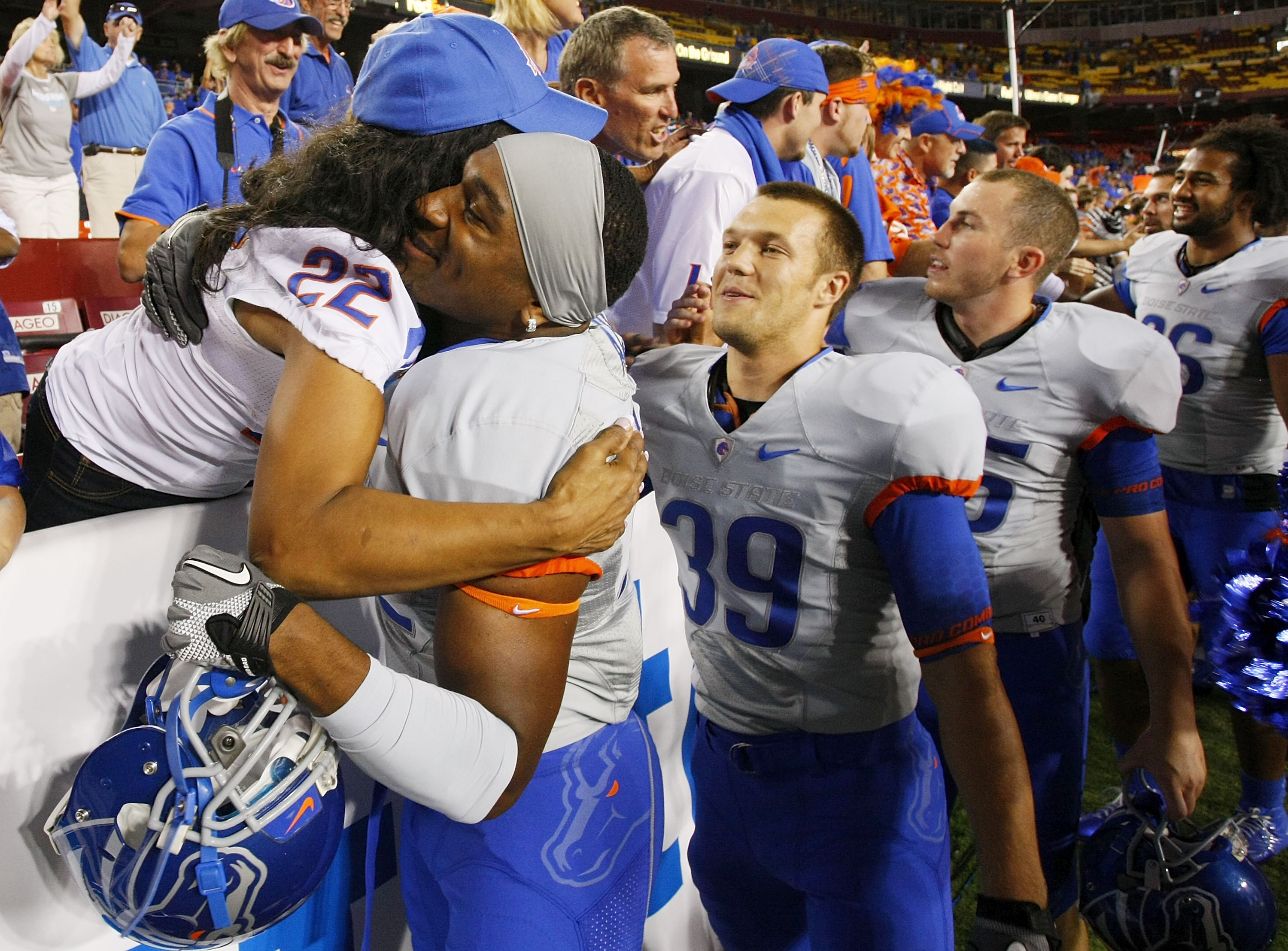 LANDOVER, MD - SEPTEMBER 06:  Linebacker #52 Derrell Acrey of the Boise State Broncos hugs a fan after the Broncos defeated the Virginia Tech Hokies 33-30 at FedExField on September 6, 2010 in Landover, Maryland.  (Photo by Geoff Burke/Getty Images)