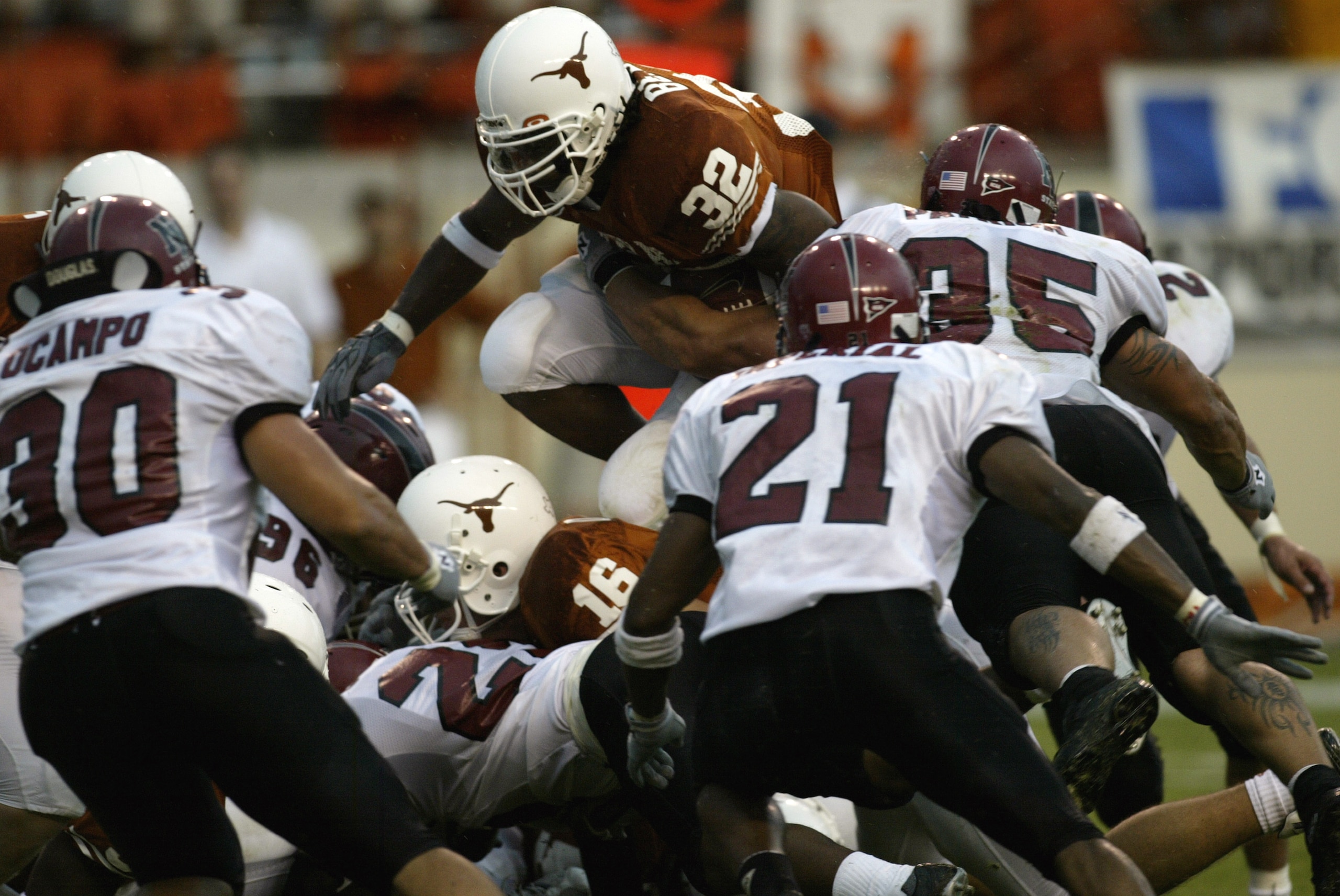 AUSTIN, TX - AUGUST 31: Running back Cedric Benson #32 of the University of Texas at Austin Longhorns leaps over the New Mexico State University Aggies during the game Texas Memorial Stadium on August 31, 2003 in Austin, Texas. Texas defeated New Mexico AUSTIN, TX - AUGUST 31: Running back Cedric Benson #32 of the University of Texas at Austin Longhorns leaps over the New Mexico State University Aggies during the game Texas Memorial Stadium on August 31, 2003 in Austin, Texas. Texas defeated New Mexico
