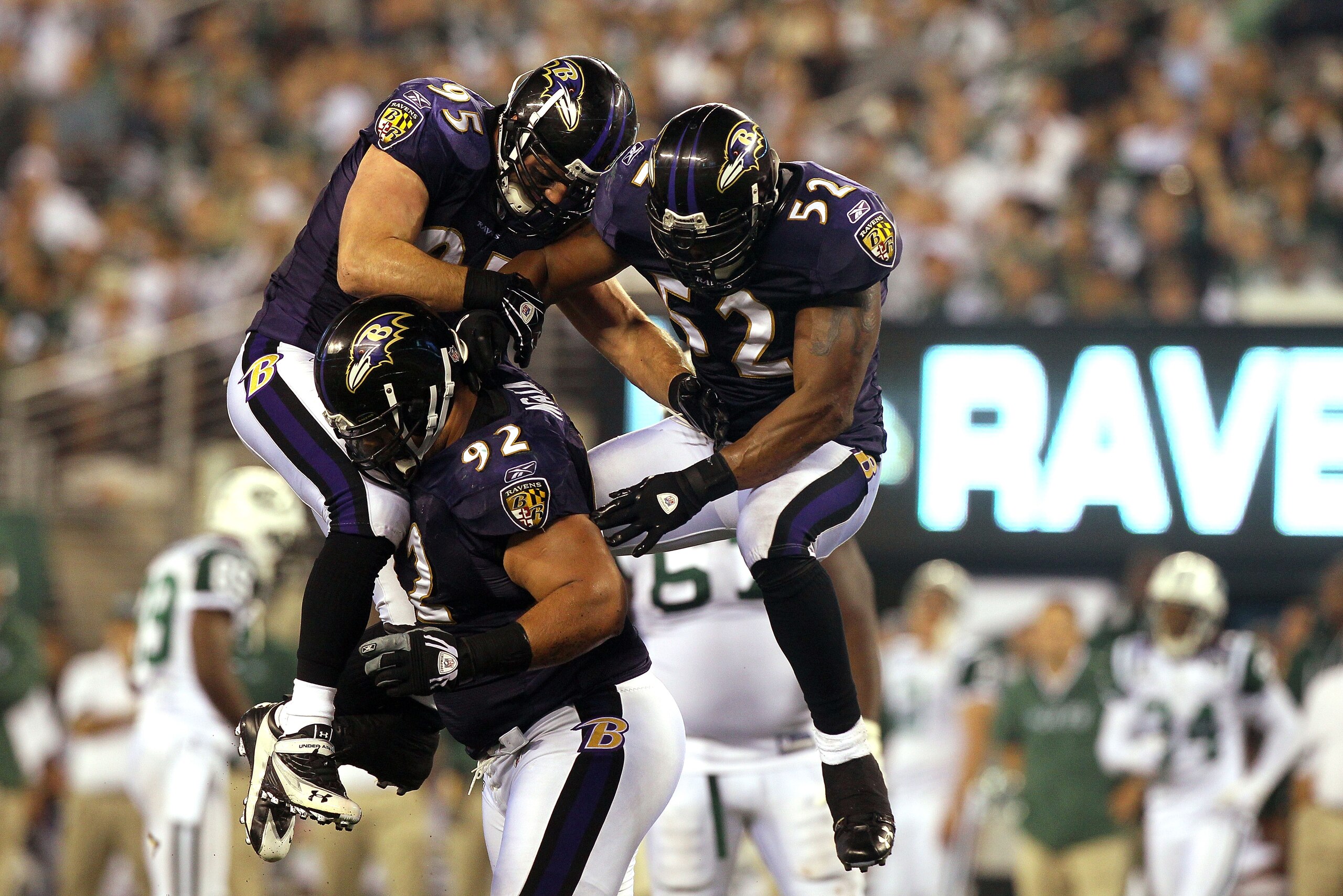 EAST RUTHERFORD, NJ - SEPTEMBER 13:  Ray Lewis #52 and Jarret Johnson #95 jump on Haloti Ngata #92 of the Baltimore Ravens after a sack in the fourth quarter against the New York Jets during their home opener at the New Meadowlands Stadium on September 13