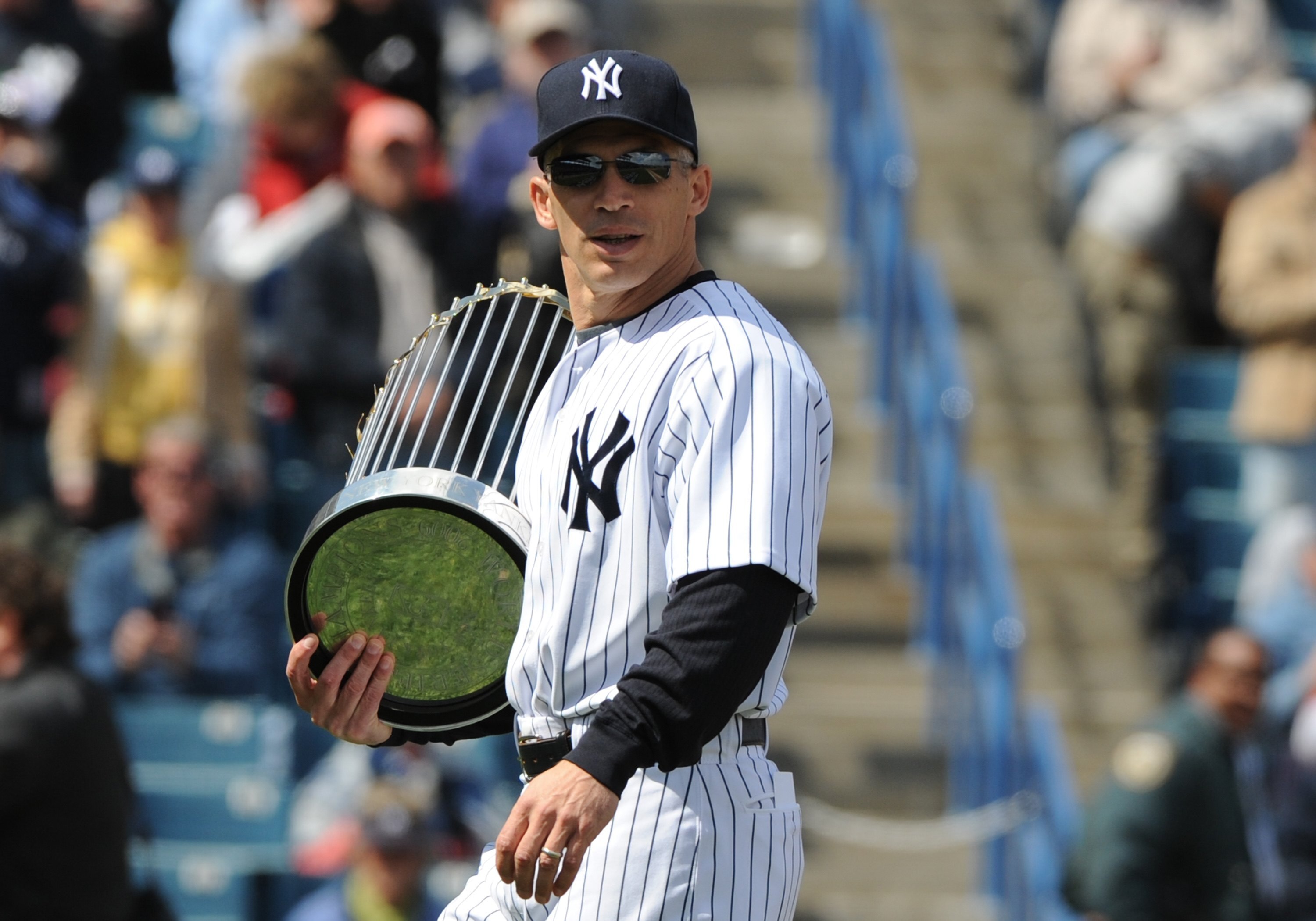 TAMPA, FL - MARCH 3: Manager Joe Girardi #28 of the New York Yankees carries the World Series trophy before play against the Pittsburgh Pirates on March 3, 2010 at the George M. Steinbrenner  Field in Tampa, Florida. (Photo by Al Messerschmidt/Getty Image