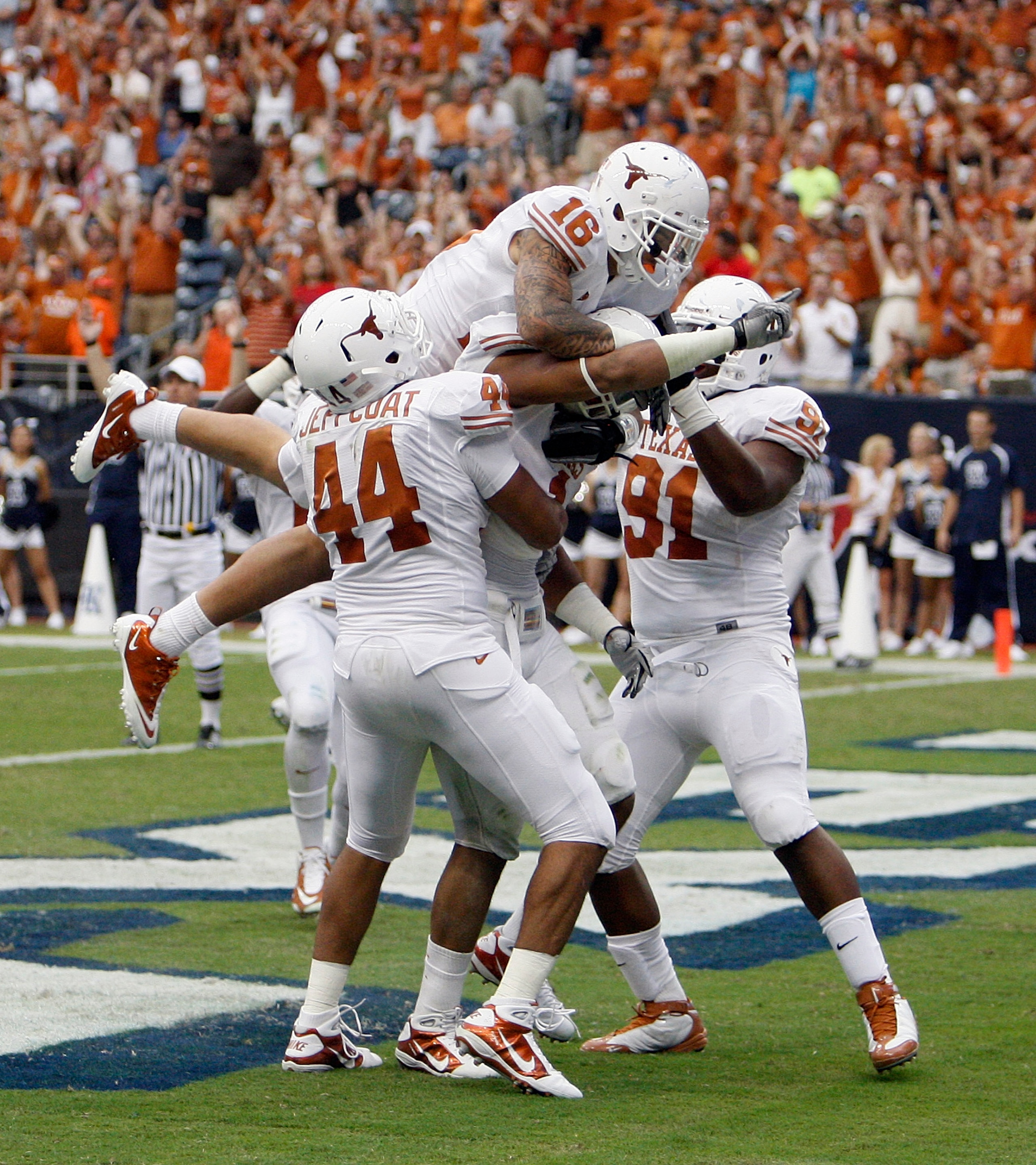 HOUSTON - SEPTEMBER 04:  Safety Kenny Vacarro #16 of the Texas Longhorns along with Jackson Jeffcoat #44 and Kheeston Randall #92 jumps on the back of linebacker Keenan Robinson #1 who recovered a fumble and scored against the Rice Owls at Reliant Stadium