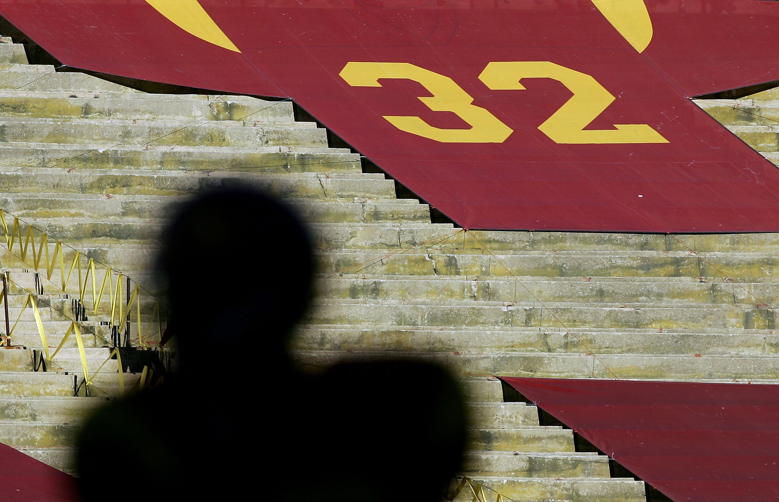 LOS ANGELES, CA - DECEMBER 03:  A silhouette of Reggie Bush #5 of the USC Trojans is seen in front of the retired #32 jersey of USC alumnus O.J. Simpson against the UCLA Bruins December 3, 2005 at the Los Angeles Memorial Coliseum in Los Angeles, Californ