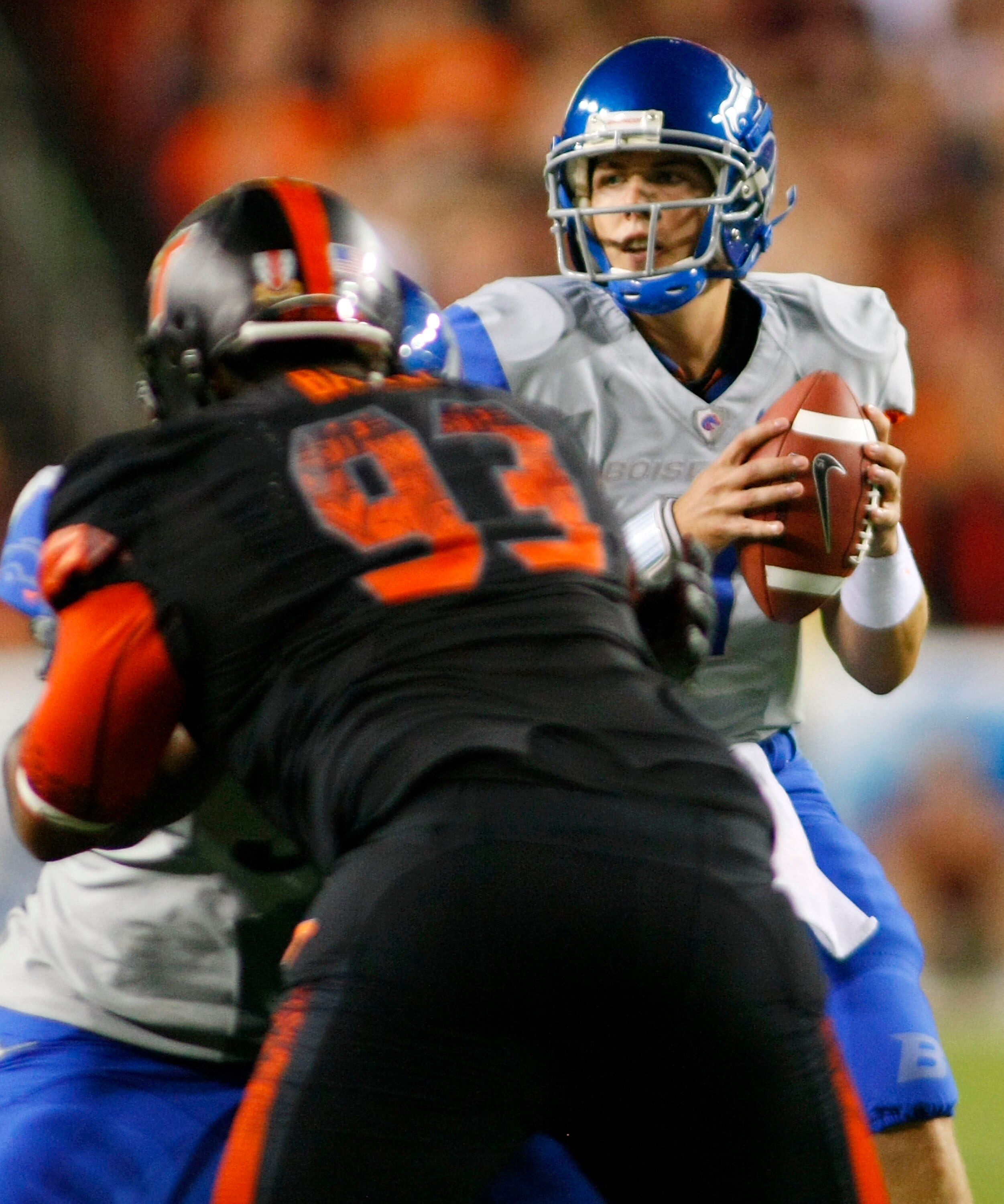LANDOVER, MD - SEPTEMBER 06: Quarterback #11 Kellen Moore of the Boise State Broncos looks to pass the ball as defensive end #93 Kwamaine Battle of the Virginia Tech Hokies is blocked at FedExField on September 6, 2010 in Landover, Maryland.  (Photo by Ge