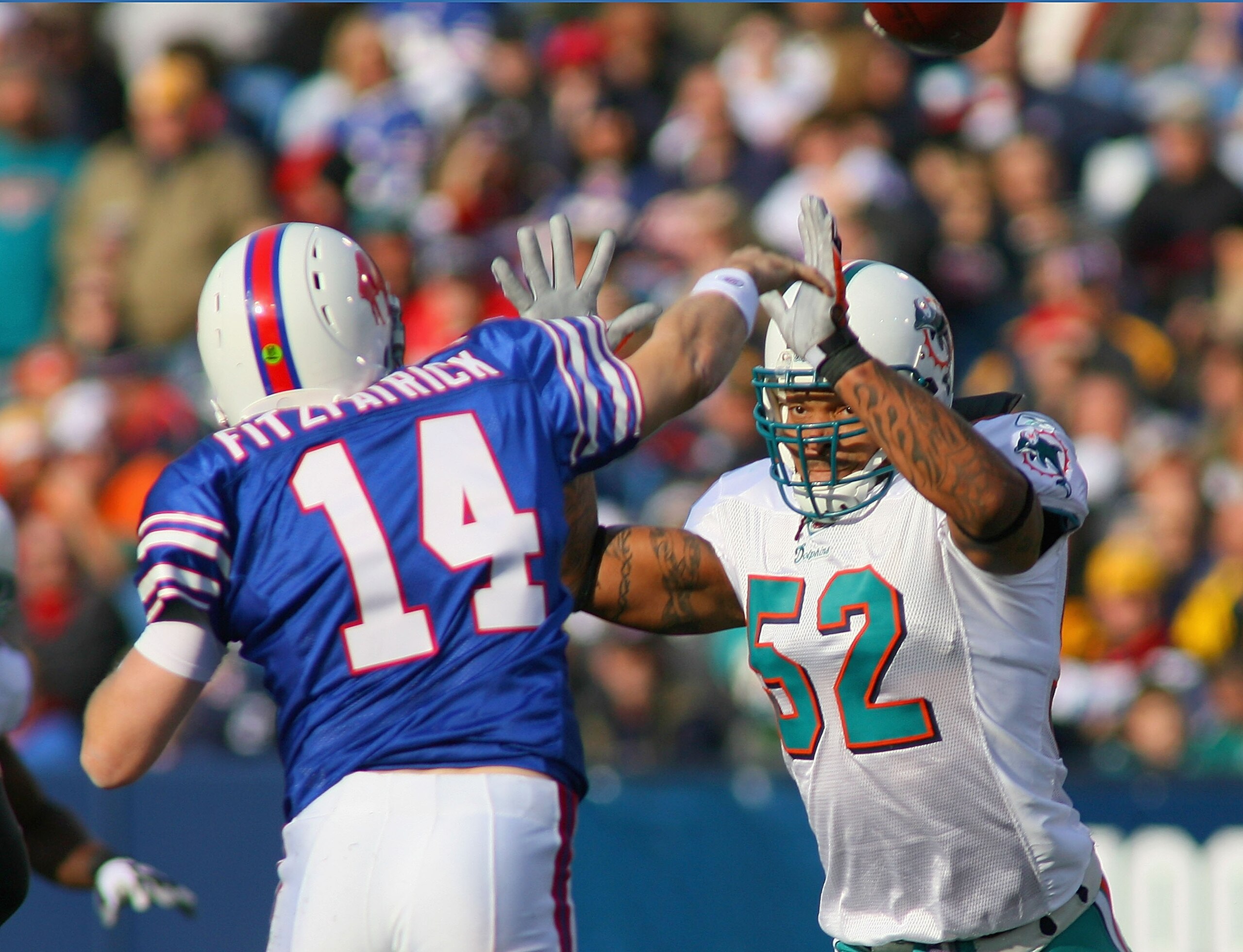 ORCHARD PARK, NY - NOVEMBER 29:  Ryan Fitzpatrick #14 of the Buffalo Bills is pressured by Channing Crowder #52 of the Miami Dolphins at Ralph Wilson Stadium on November 29, 2009 in Orchard Park, New York. Buffalo won 31-14.  (Photo by Rick Stewart/Getty