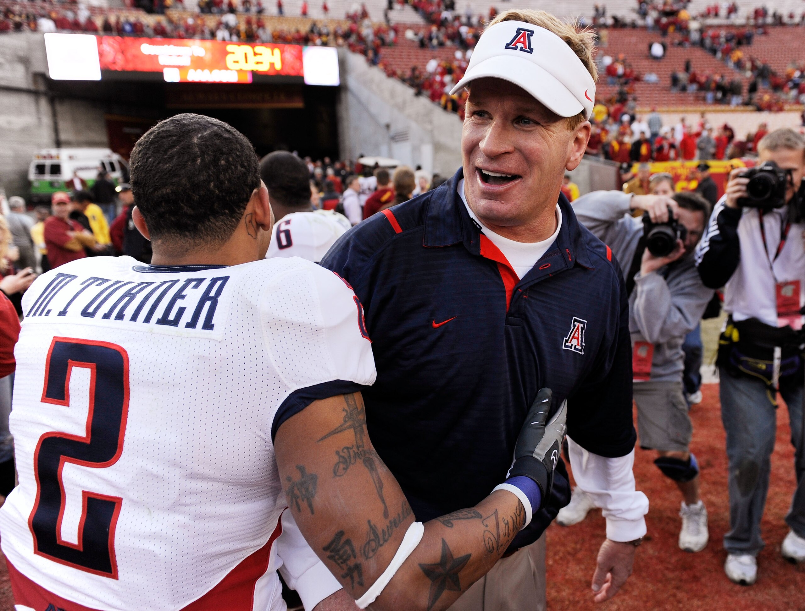 LOS ANGELES, CA - DECEMBER 05:  Coach Mike Stoops of the Arizona Wildcats celebrates with cornerback Mike Turner #2 after beating the USC Trojans 21-17 in the NCAA college football game at the Los Angeles Coliseum on December 5, 2009 in Los Angeles, Calif