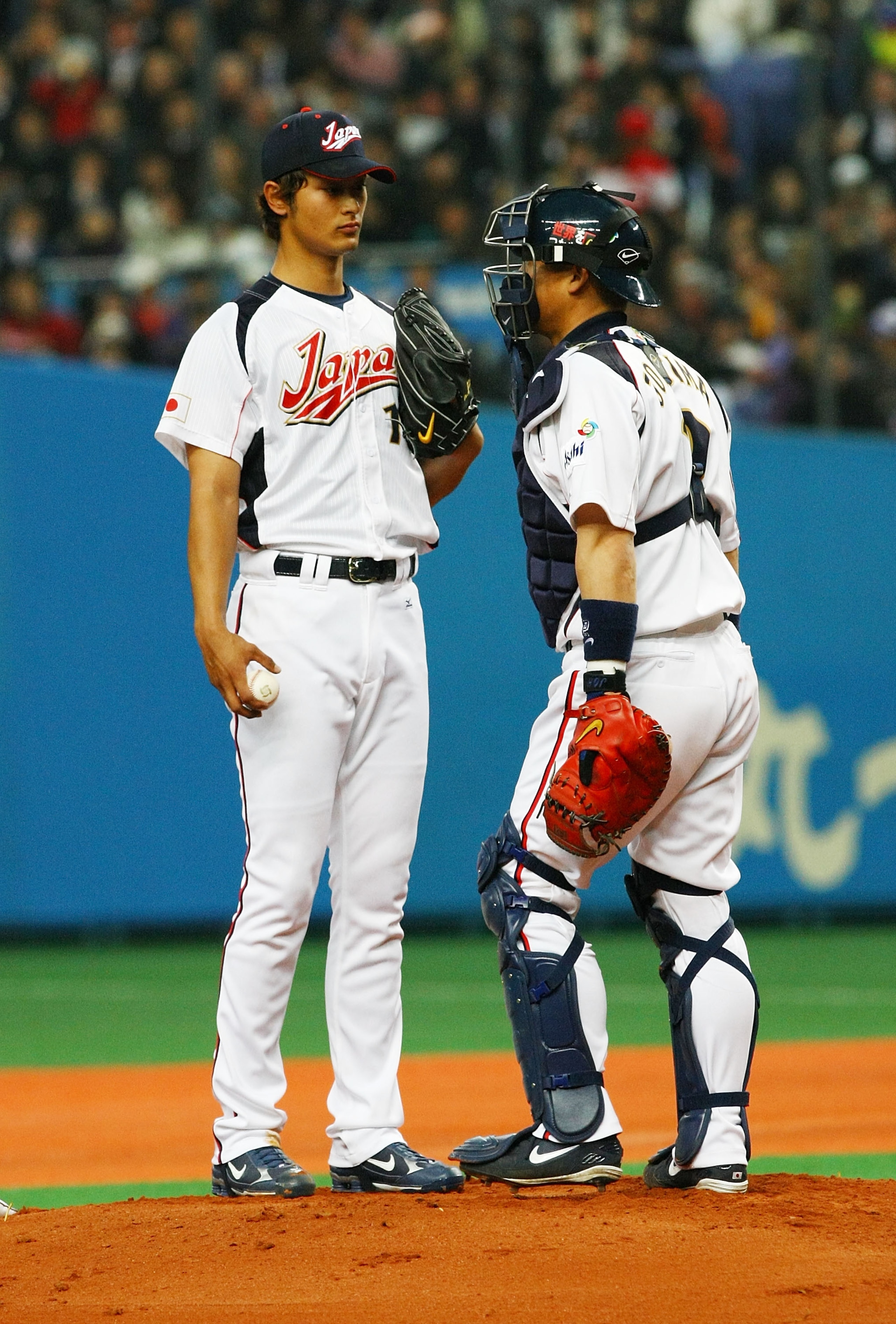 OSAKA, JAPAN - FEBRUARY 24:  Starting Pictcher Yu Darvish #11 and Chatcher Kenji Jojima #2 of Japan talk during an exhibition match between Japan and Australia at Kyocera Dome Osaka on February 24, 2009 in Osaka, Japan.  (Photo by Junko Kimura/Getty Image