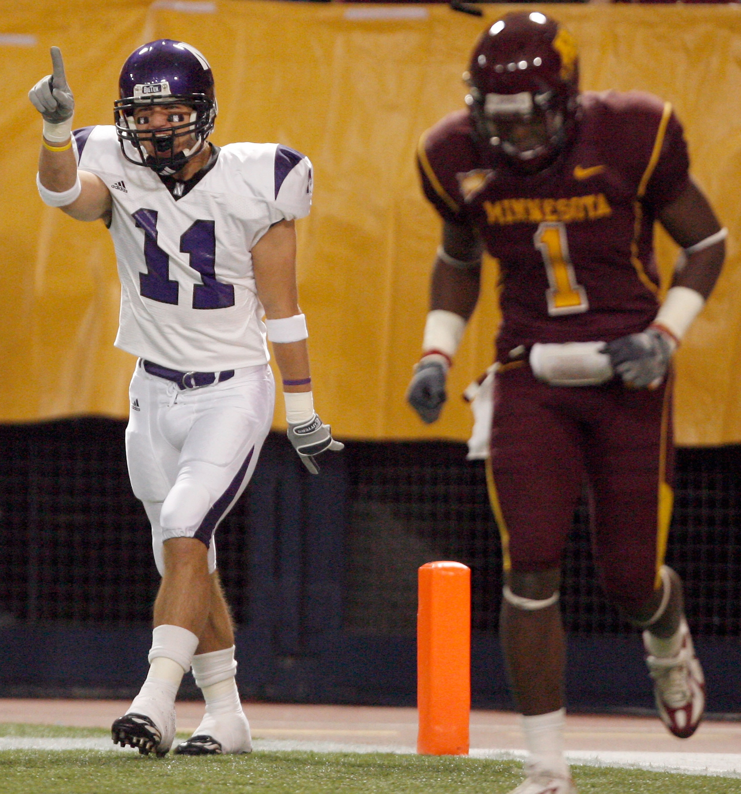 MINNEAPOLIS - NOVEMBER 01:  Jeremy Ebert #11 of the Northwestern Wildcats celebrates his touchdown for a 7-0 lead in front of Tramaine Brock #1 of the Minnesota Golden Gophers during the first quarter at the Hubert H.Humphrey Metrodome on November 1, 2008