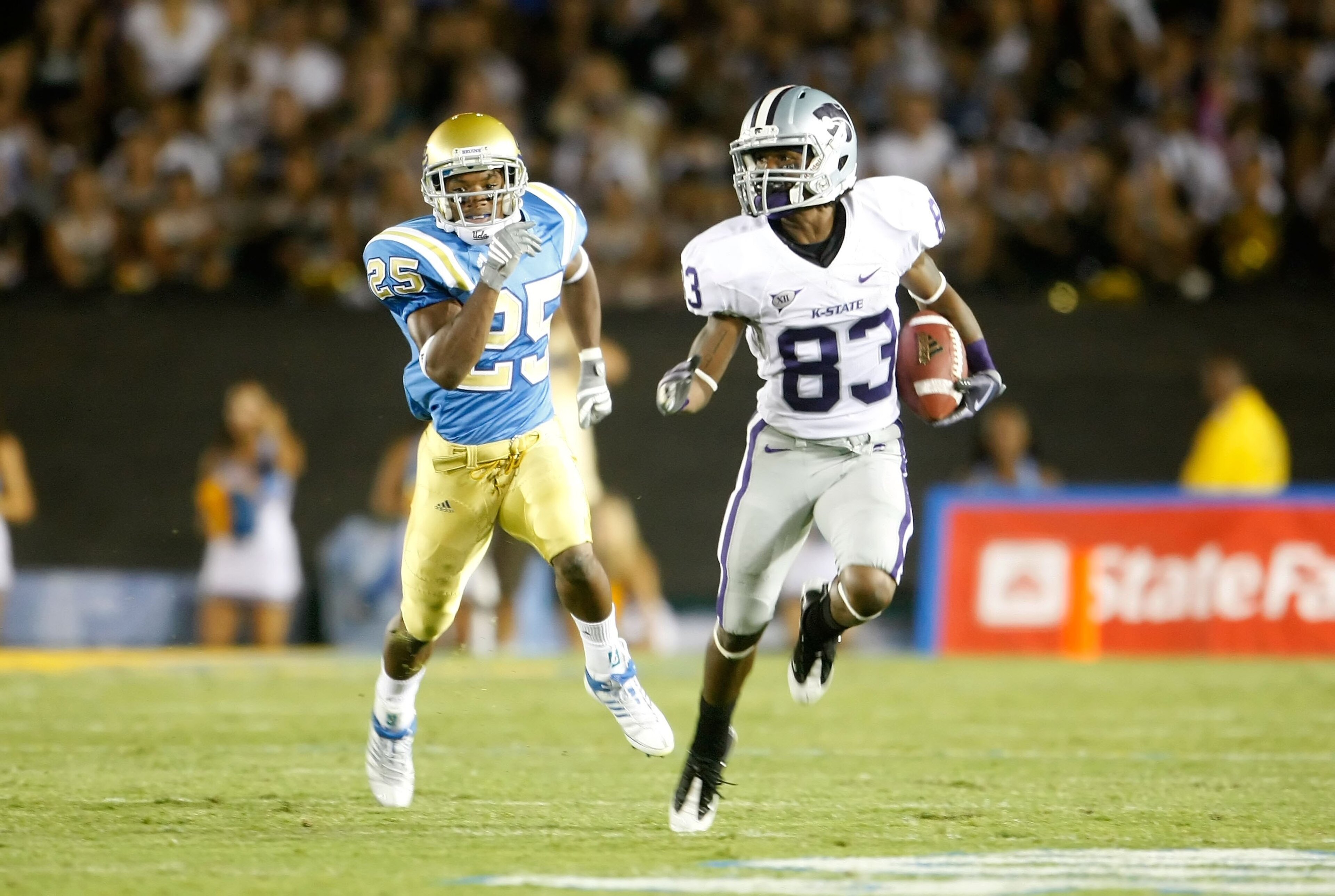 PASADENA, CA - SEPTEMBER 19:  Brandon Banks #83 of the Kansas State Wildcats returns the ball while being pursued by Damien Thigpen #25 of the UCLA Bruins at the Rose Bowl on September 19, 2009 in Pasadena, California. UCLA defeated Kansas State 23-9.  (P
