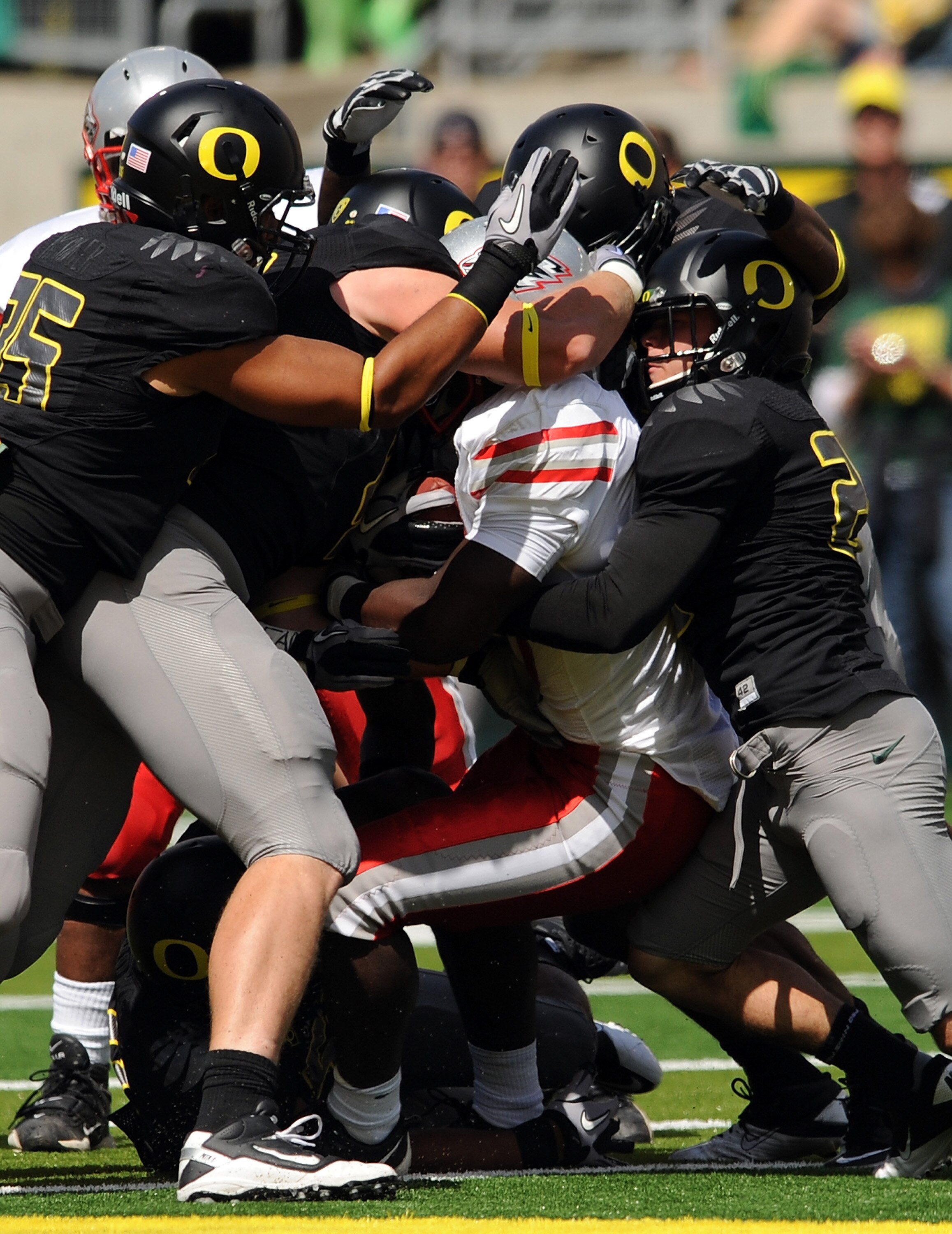 EUGENE, OR - SEPTEMBER 04: Linebacker Casey Matthews #55 of the Oregon Ducks (L) and free safety John Boyett #20 of the Oregon Ducks (R) gang up to tackle running back Demond Dennis #1 of the New Mexico Lobos in the first quarter of the game at Autzen Sta