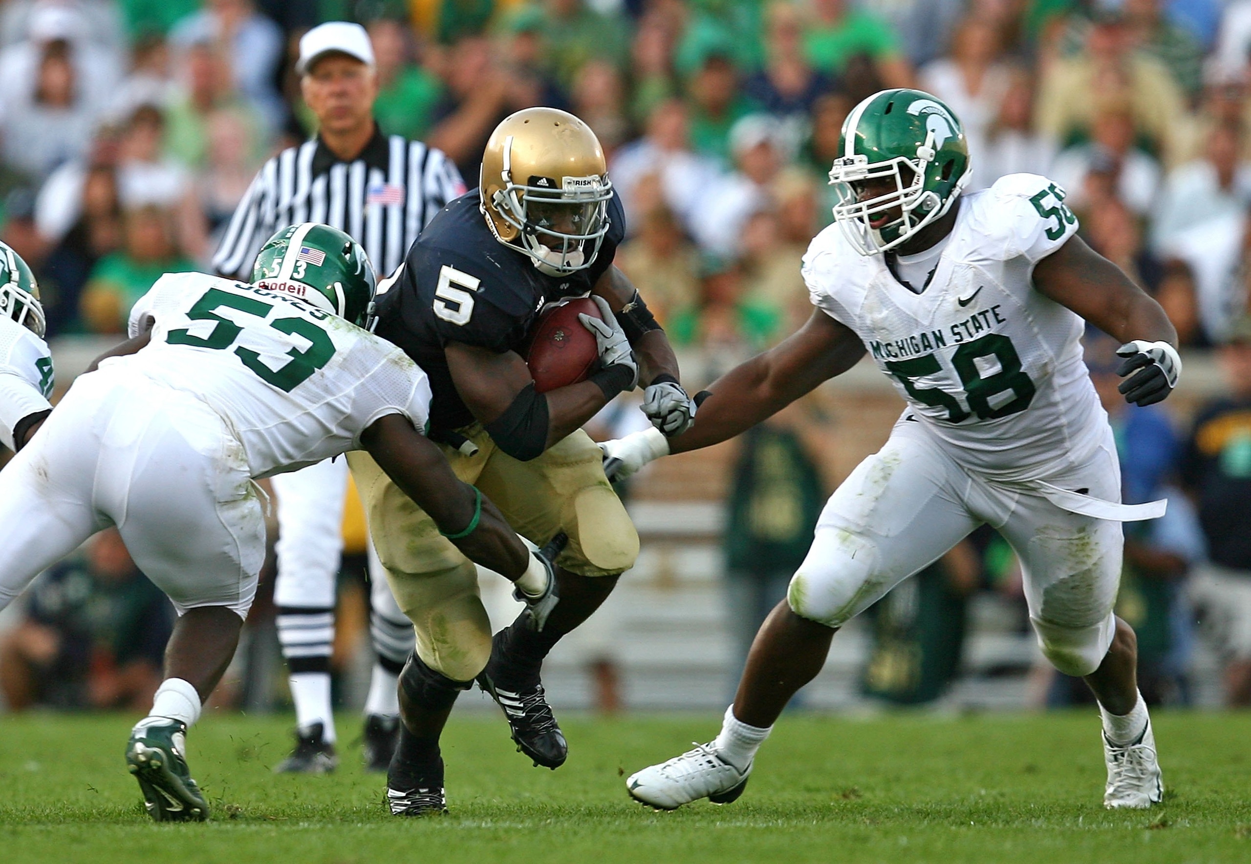 SOUTH BEND, IN - SEPTEMBER 19: Armando Allen #5 of the Notre Dame Fighting Irish runs against Greg Jones #53 and Trevor Anderson #58 of the Michigan State Spartans on September 19, 2009 at Notre Dame Stadium in South Bend, Indiana. Notre Dame defeated Mic