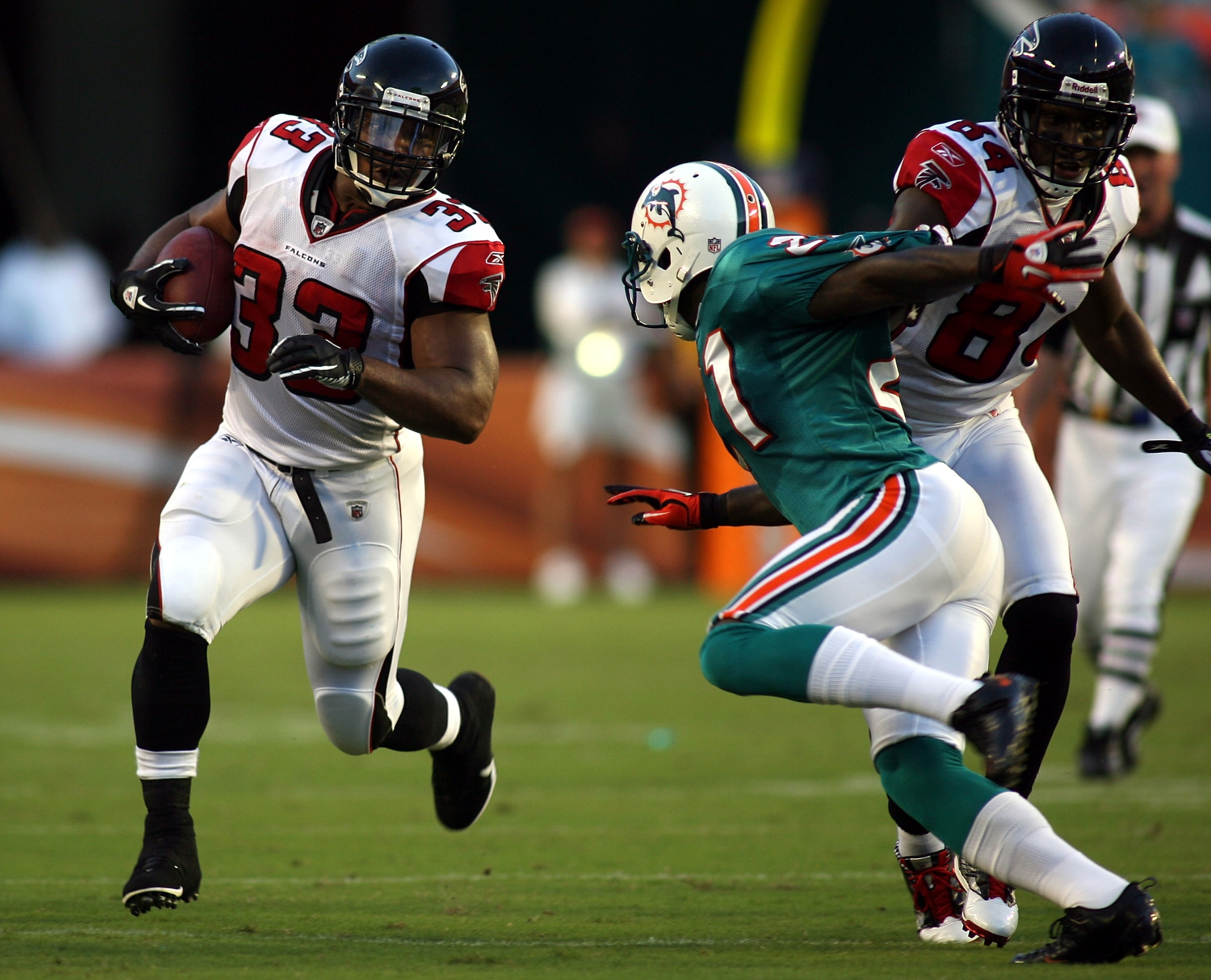 MIAMI - AUGUST 27:  Running back Michael Turner #33 (L) of the Atlanta Falcons runs against the Miami Dolphins during a preseason game at Sun Life Stadium on August 27, 2010 in Miami, Florida.  (Photo by Marc Serota/Getty Images)