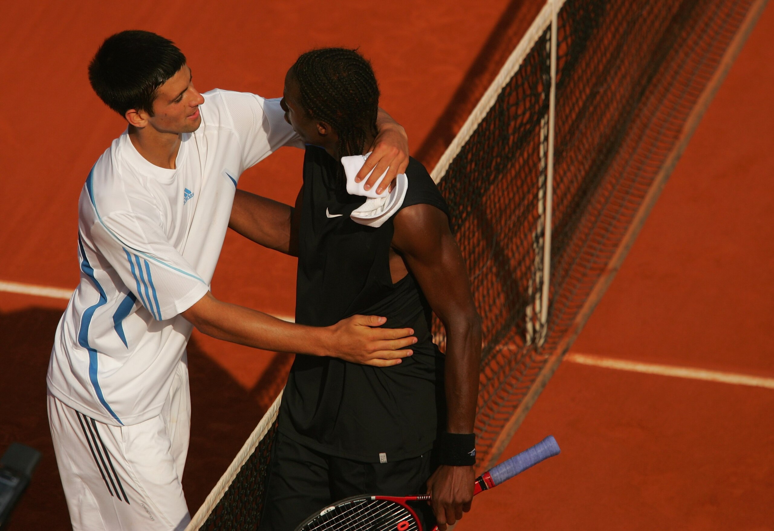 PARIS - JUNE 05: Novak Djokovic (L) of Serbia and Montenegro hugs Gael Monfils of France during day nine of the French Open at Roland Garros on June 5, 2006 in Paris, France. (Photo by Matthew Stockman/Getty Images) PARIS - JUNE 05: Novak Djokovic (L) of Serbia and Montenegro hugs Gael Monfils of France during day nine of the French Open at Roland Garros on June 5, 2006 in Paris, France. (Photo by Matthew Stockman/Getty Images)