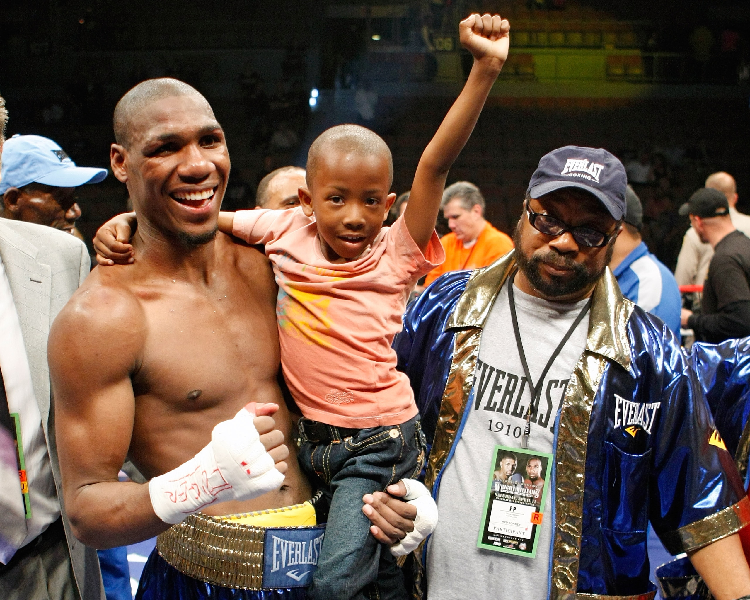 LAS VEGAS - APRIL 11:  Paul Williams holds his son Paul Williams Jr. as he and his trainer George Peterson celebrate defeating Winky Wright in a unanimous decision in their middleweight bout at the Mandalay Bay Events Center April 11, 2009 in Las Vegas, N