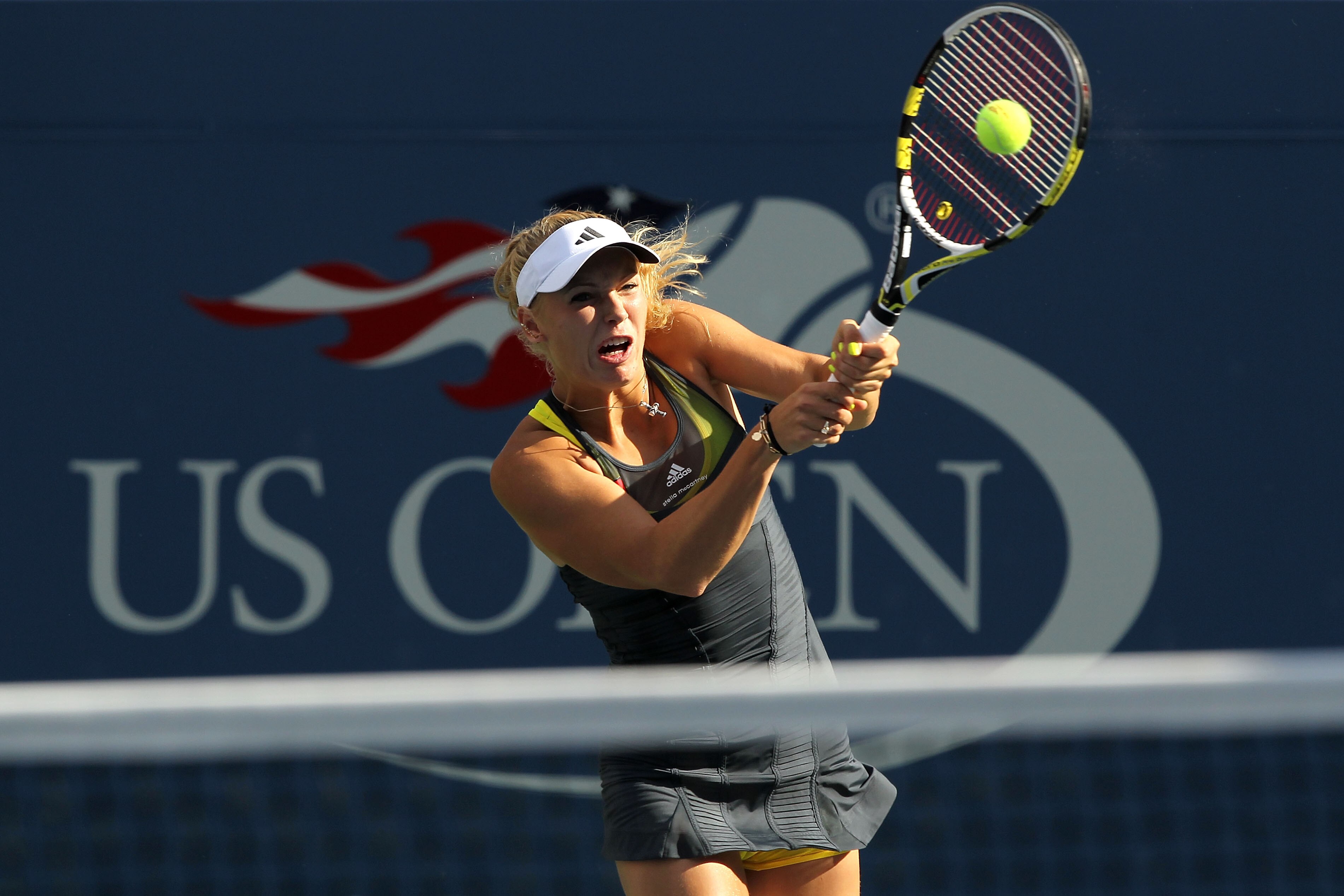 NEW YORK - SEPTEMBER 06:  Caroline Wozniacki of Denmark returns a shot against Maria Sharapova of Russia during the women's singles match on day eight of the 2010 U.S. Open at the USTA Billie Jean King National Tennis Center on September 6, 2010 in the Fl