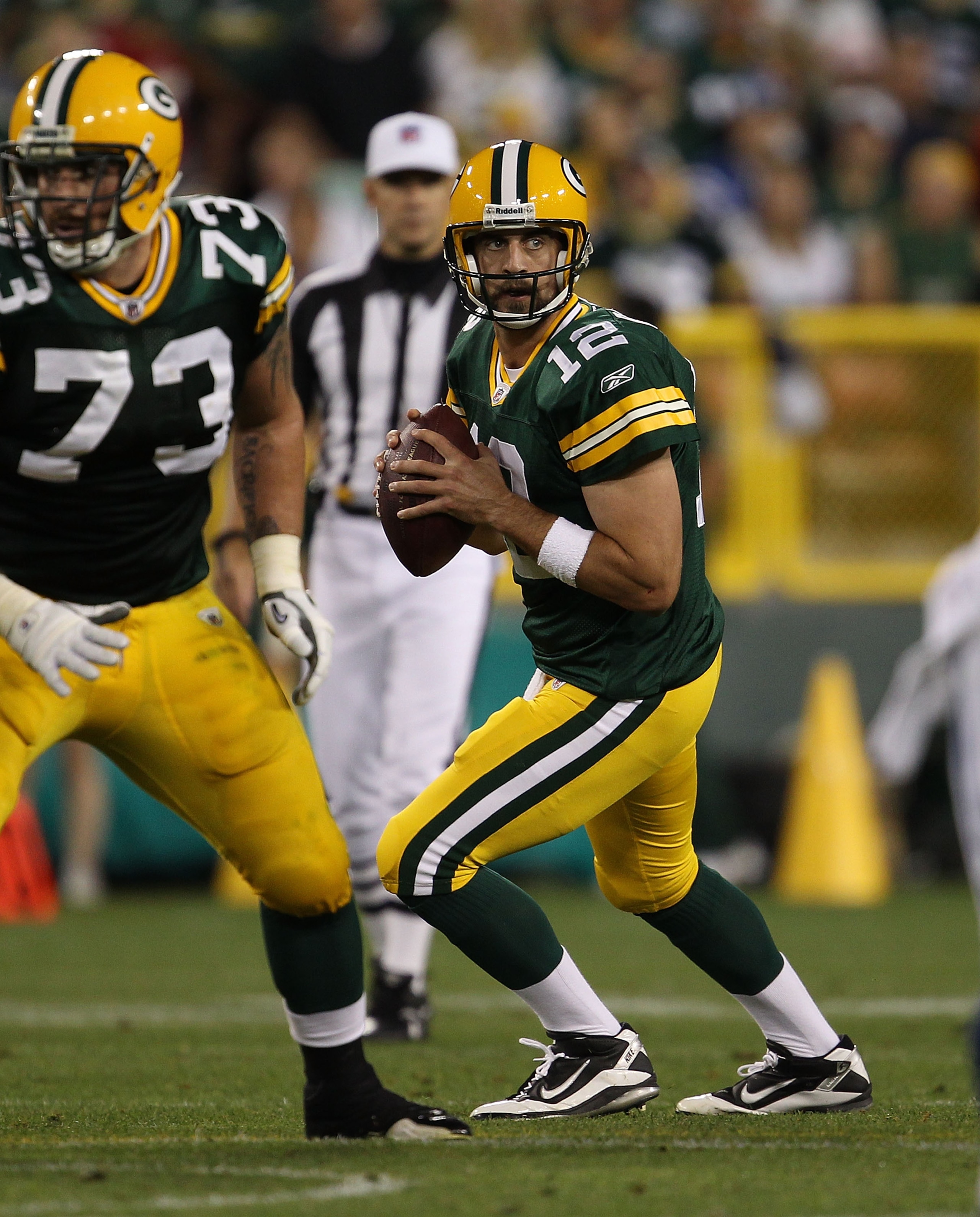 GREEN BAY, WI - AUGUST 26: Aaron Rodgers #12 of the Green Bay Packers drops back to look for a receiver as teammate Daryn Colledge #73 looks to block against the Indianapolis Colts during a preseason game at Lambeau Field on August 26, 2010 in Green Bay, GREEN BAY, WI - AUGUST 26: Aaron Rodgers #12 of the Green Bay Packers drops back to look for a receiver as teammate Daryn Colledge #73 looks to block against the Indianapolis Colts during a preseason game at Lambeau Field on August 26, 2010 in Green Bay,