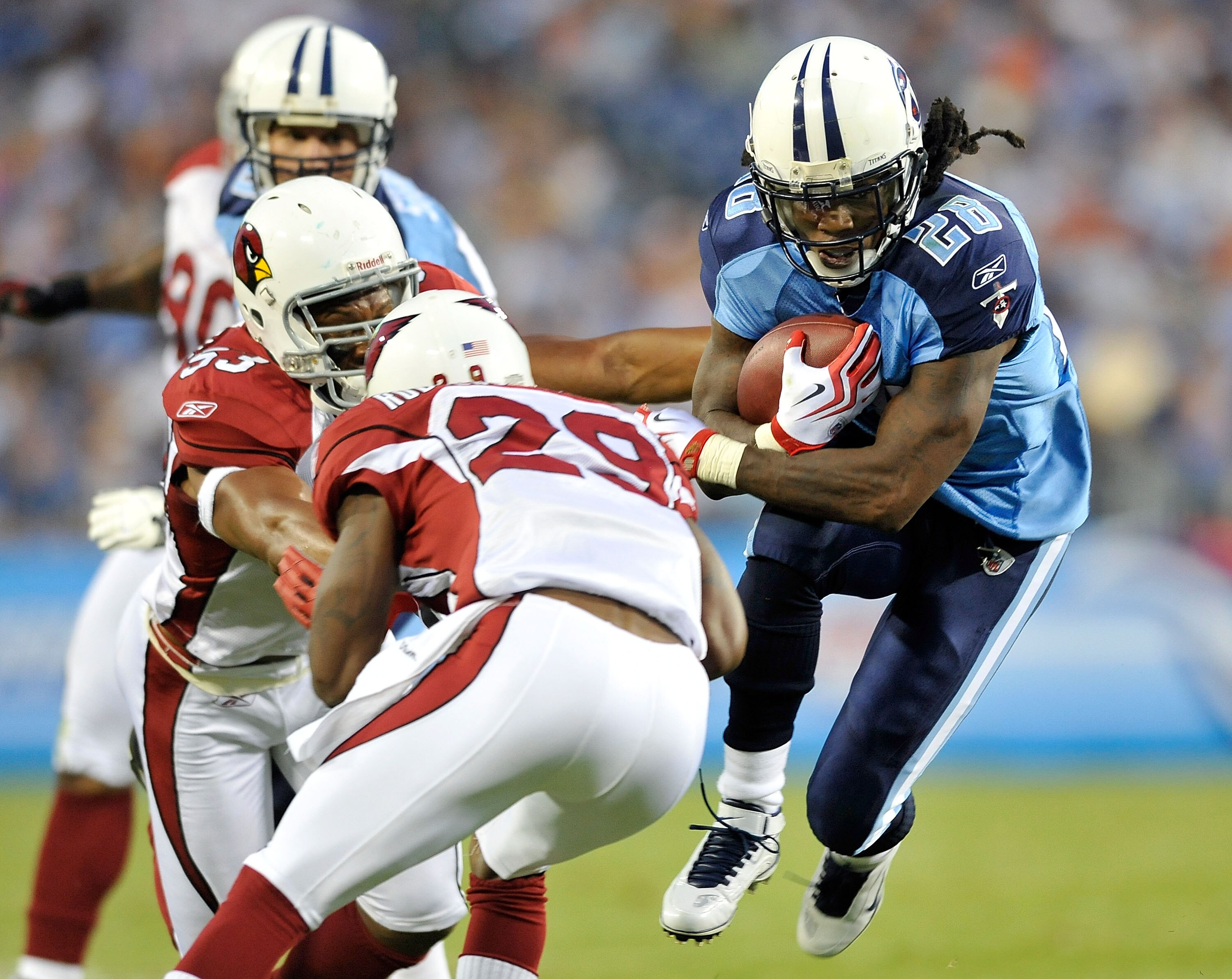 NASHVILLE, TN - AUGUST 23:  Chris Johnson #28 of the Tennessee Titans avoids defenders Clark Haggans #53 and Dominique Rogers-Cromartie #29 of te Arizona Cardinals during the first half of a preseason game at LP Field on August 23, 2010 in Nashville, Tenn