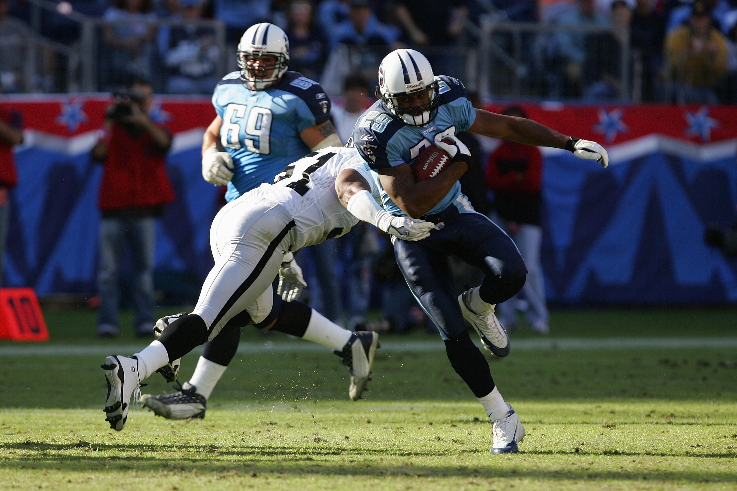 NASHVILLE, TN - OCTOBER 30:  Running back Chris Brown #29 of the Tennessee Titans runs through a tackle by linebacker Tim Johnson #51 of the Oakland Raiders during a NFL game at the Coliseum on October 30, 2005 in Nashville, Tennessee.  The Raiders won 34
