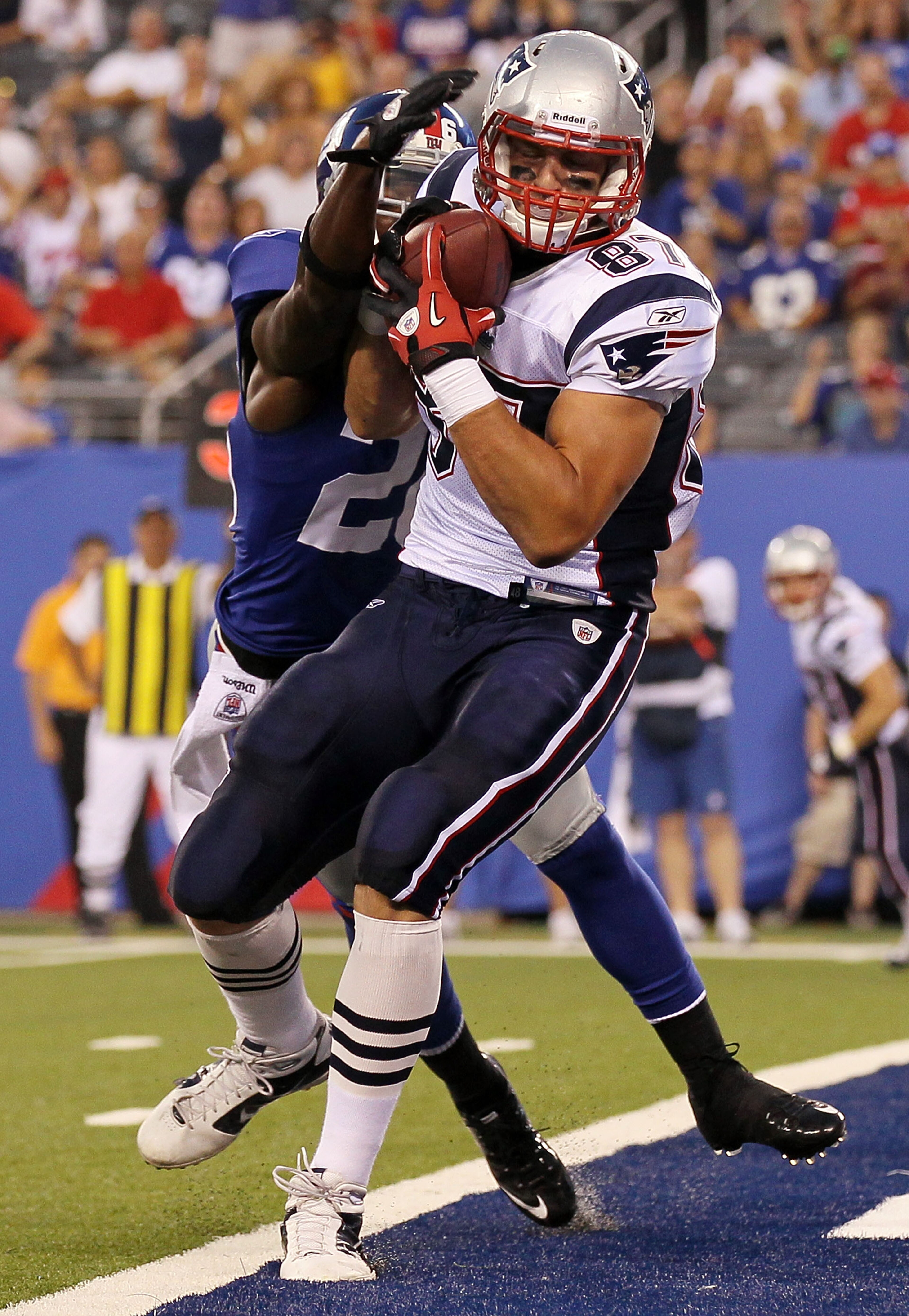 EAST RUTHERFORD, NJ - SEPTEMBER 02:  Rob Gronkowski #87 of the New England Patriots carries a reception into the endzone past Antrel Rolle #26 of the New York Giants for a first quarter touchdown on September 2, 2010 at the New Meadowlands Stadium in East