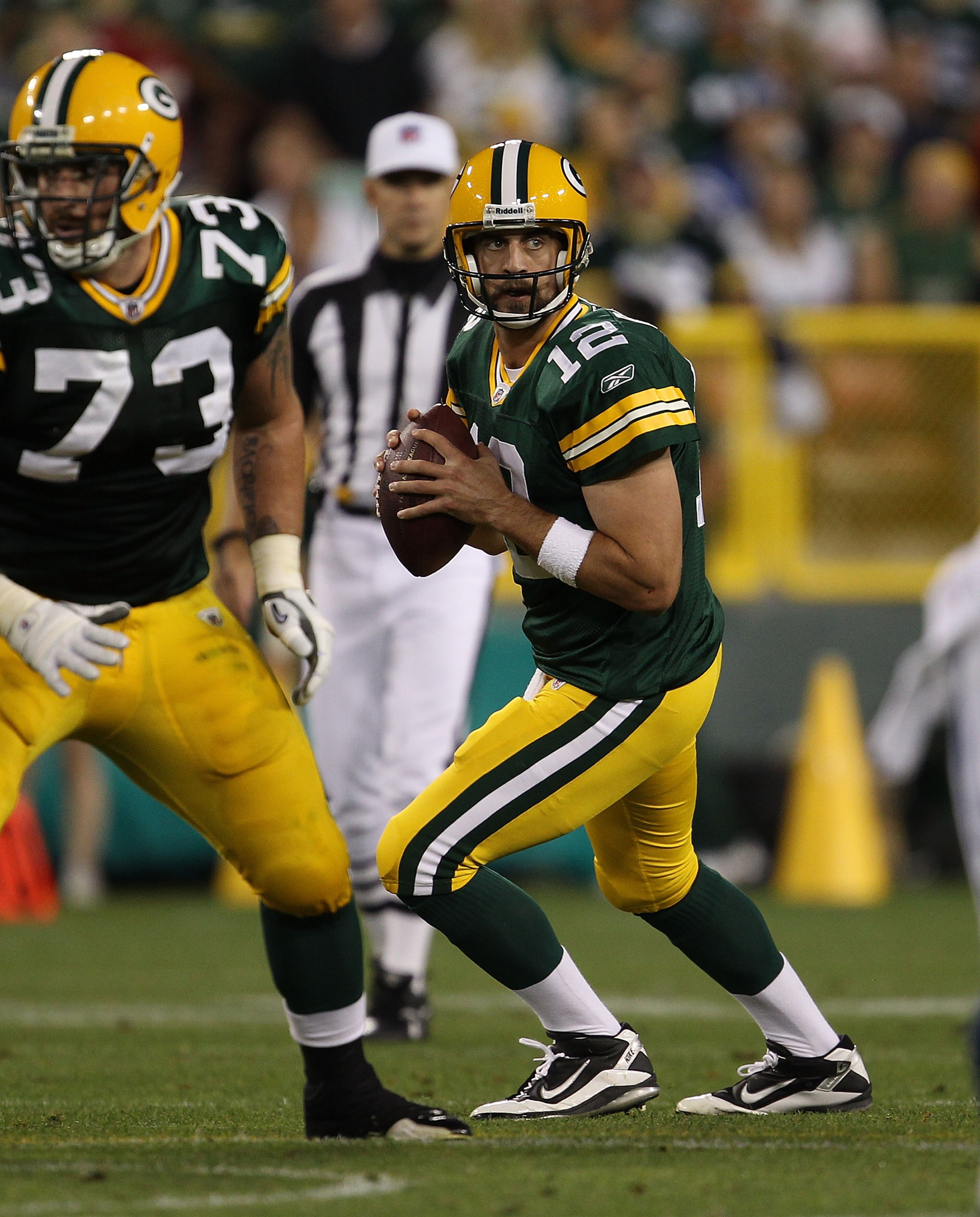 GREEN BAY, WI - AUGUST 26: Aaron Rodgers #12 of the Green Bay Packers drops back to look for a receiver as teammate Daryn Colledge #73 looks to block against the Indianapolis Colts during a preseason game at Lambeau Field on August 26, 2010 in Green Bay, GREEN BAY, WI - AUGUST 26: Aaron Rodgers #12 of the Green Bay Packers drops back to look for a receiver as teammate Daryn Colledge #73 looks to block against the Indianapolis Colts during a preseason game at Lambeau Field on August 26, 2010 in Green Bay,
