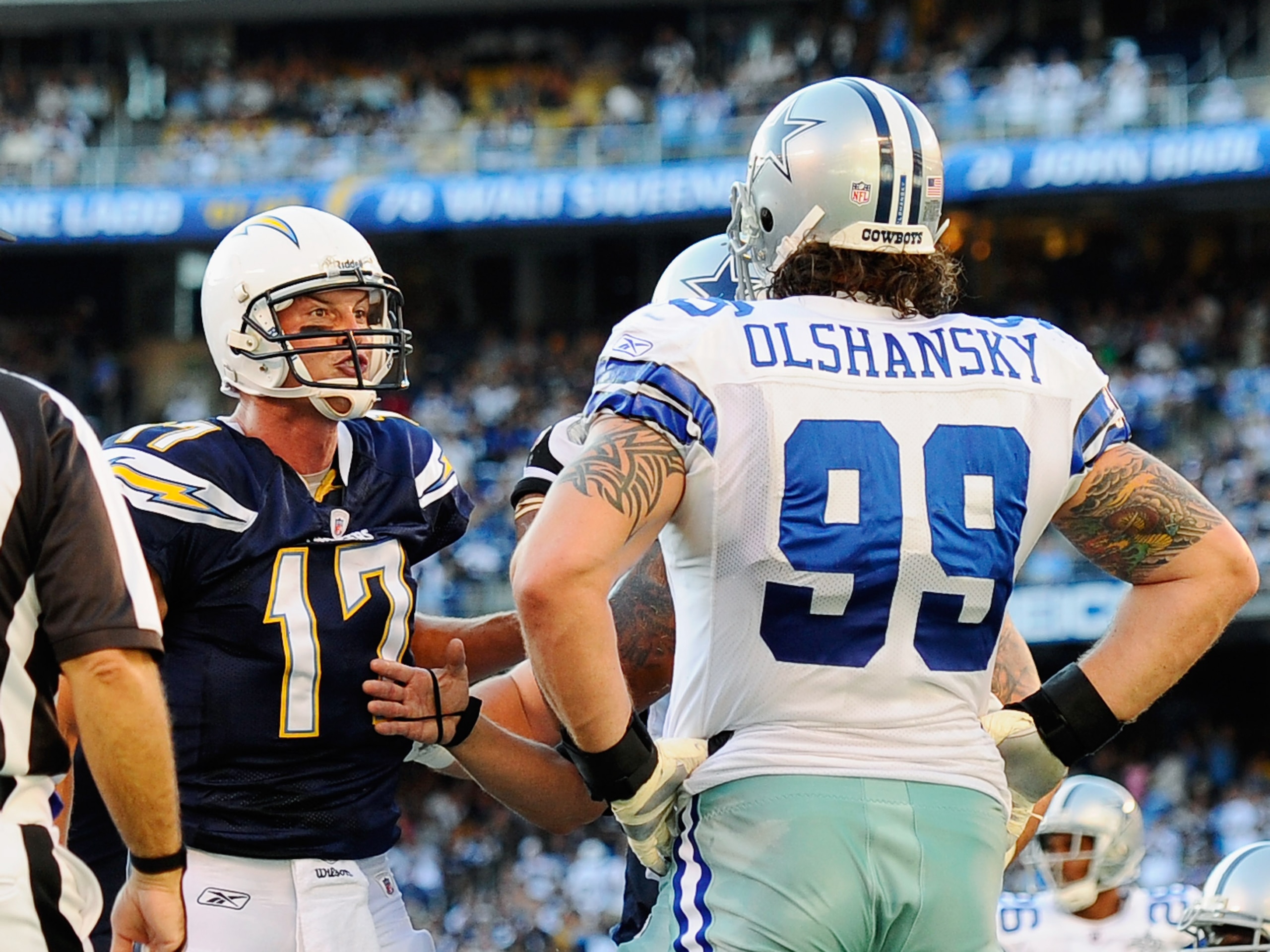 SAN DIEGO - AUGUST 21:  Quarterback Philip Rivers #17 of the San Diego Chargers reacts to Igor Olshansky #99 of the Dallas Cowboys after scoring a touchdown on a one yard rush to the end zone during their pre-season NFL football game at Qualcomm Stadium o