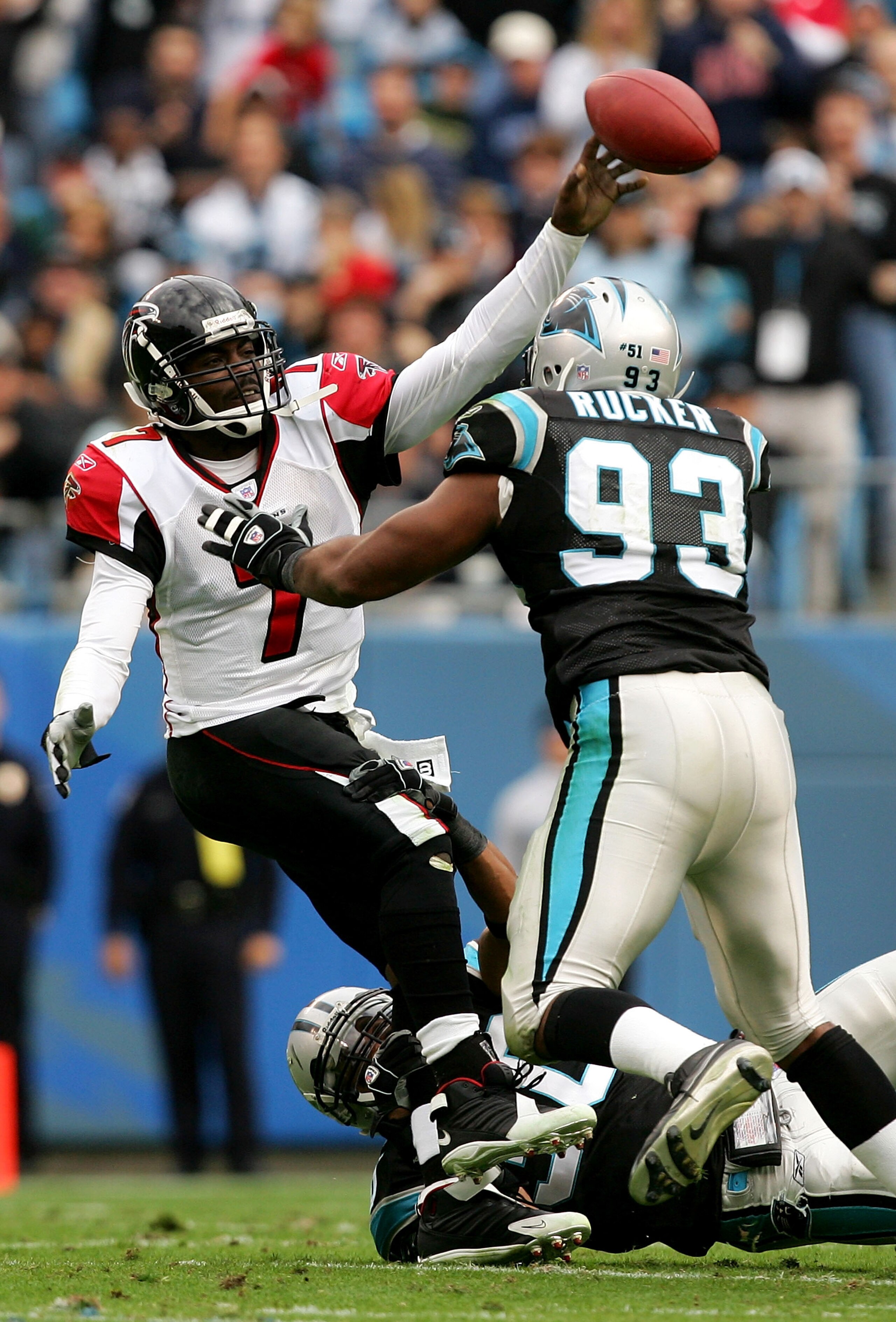 CHARLOTTE, NC - DECEMBER 4:  Michael Vick #7 of the Atlanta Falcons is sacked by Michael Rucker #93 and Mike Minter #30 of the Carolina Panthers on December 4, 2005 at Bank of America Stadium in Charlotte, North Carolina.  (Photo by Streeter Lecka/Getty I