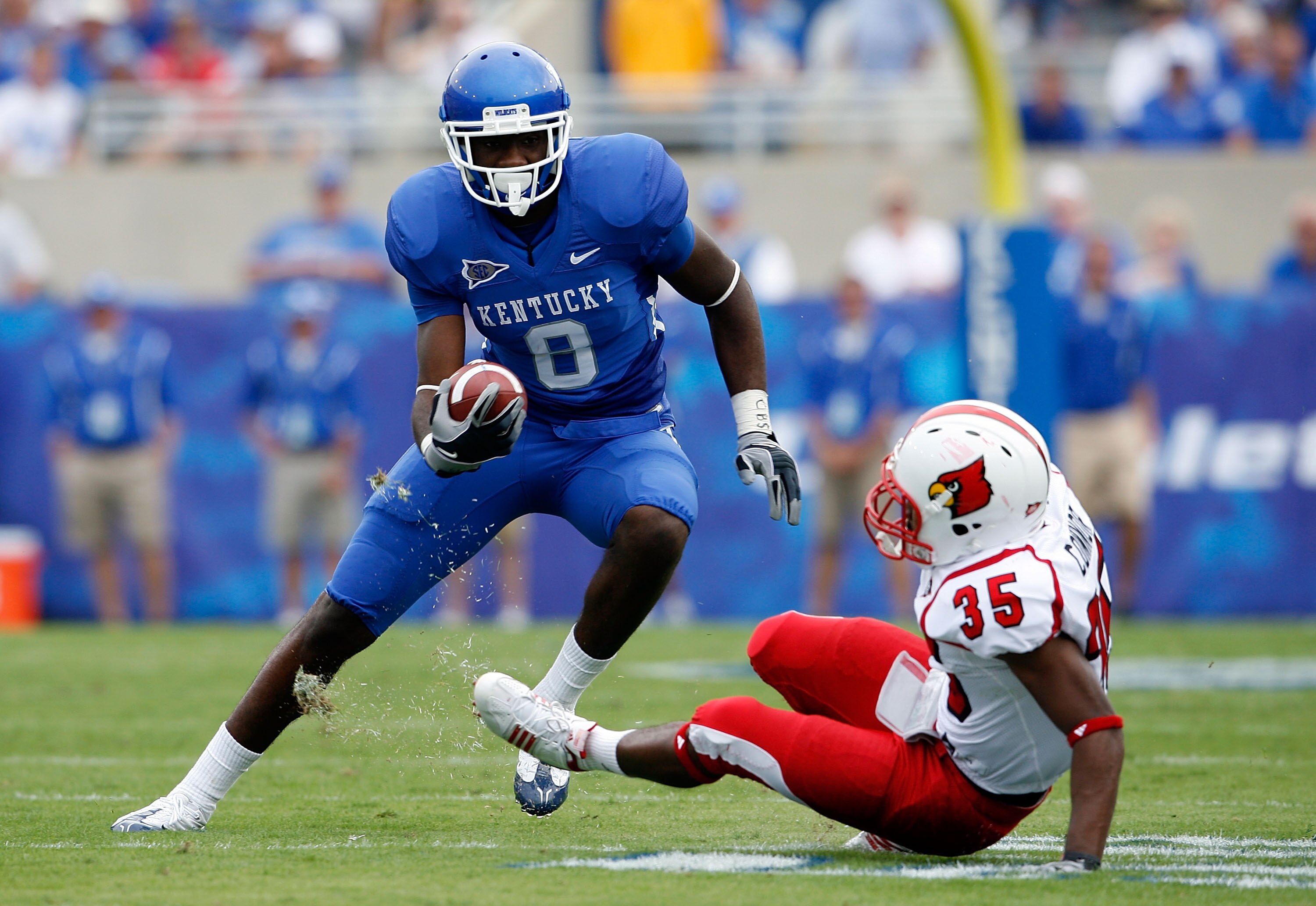 LEXINGTON, KY - SEPTEMBER 19:  Chris Matthews #8 of the Kentucky Wildcats runs with the ball while defended by Anthony Conner #35 of the Louisville Cardinals during the game at Commonwealth Stadium on September 19, 2009 in Lexington, Kentucky.  (Photo by
