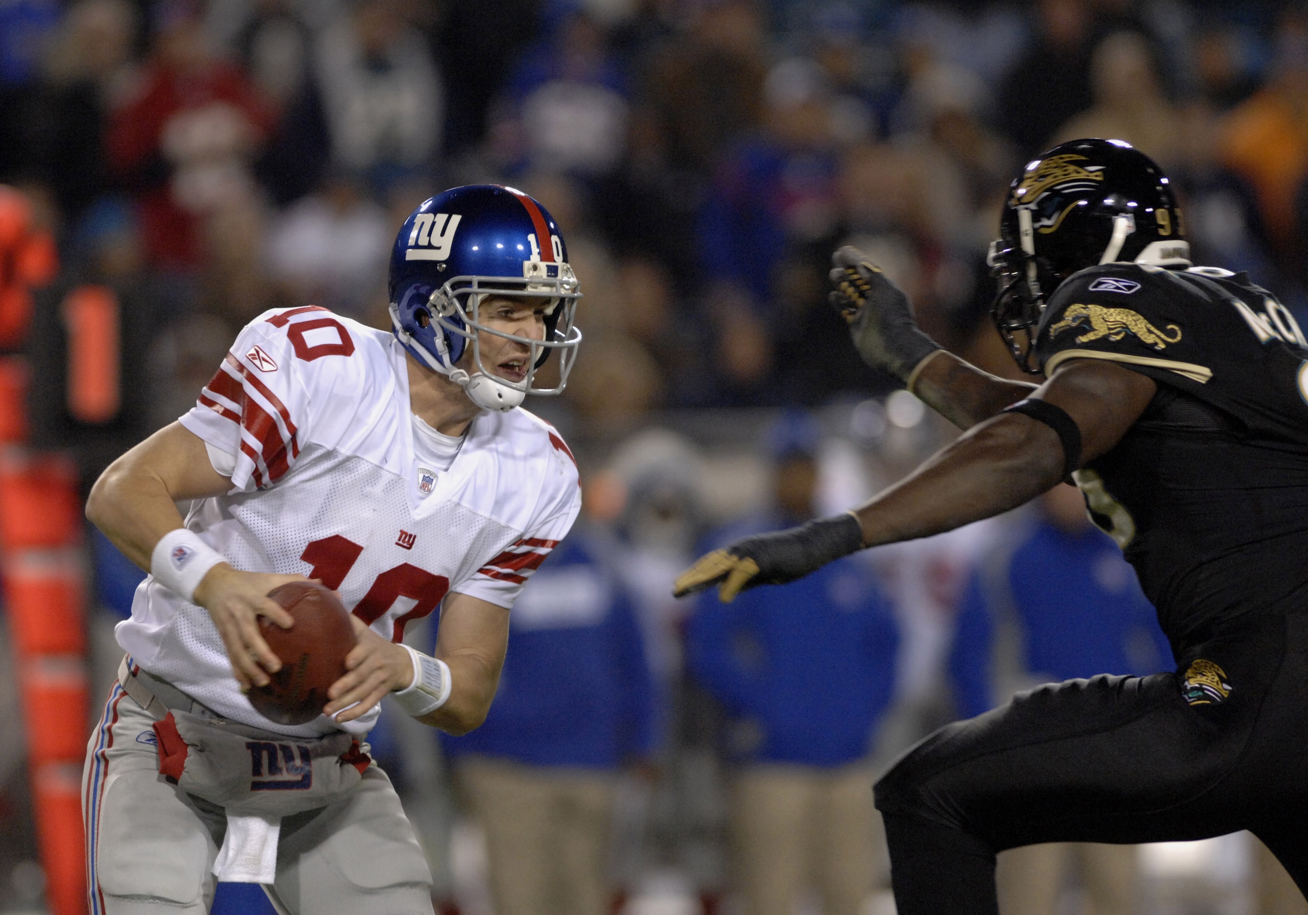 New York Giants quarterback Eli Manning dodges the pass rush of  the Jacksonville Jaguars on ESPN Monday Night Football Nov. 20, 2006 in Jacksonville.  The Jaguars won 26 - 10.  (Photo by Al Messerschmidt/Getty Images)