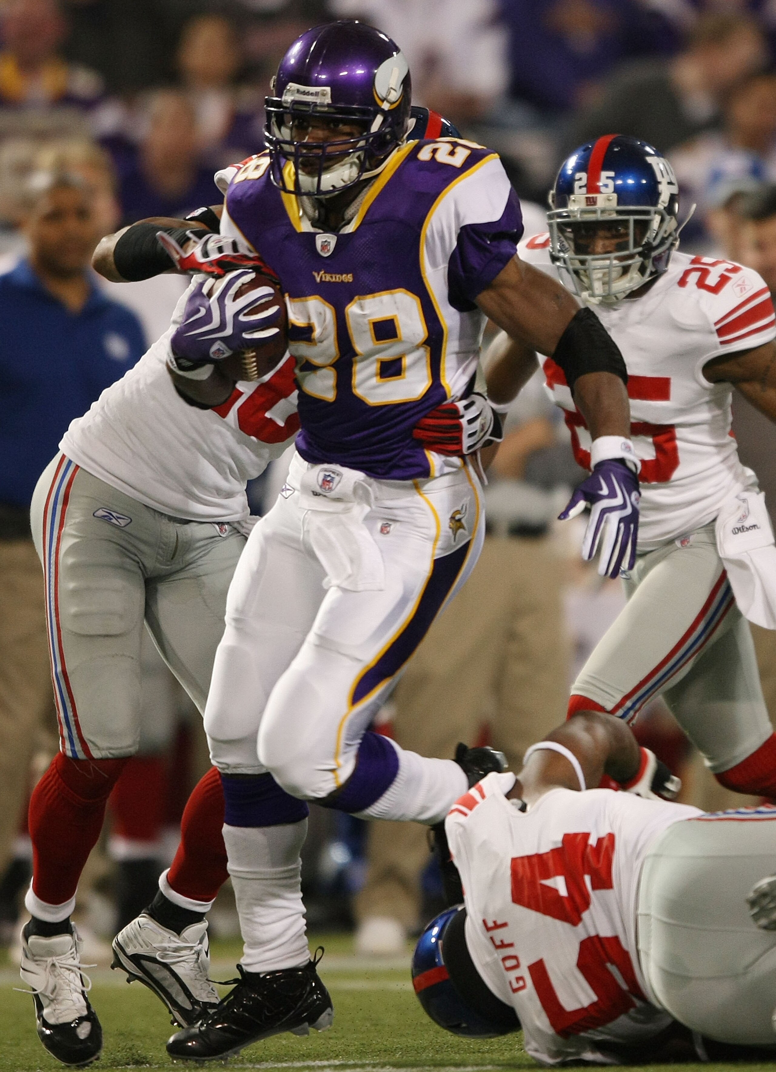 MINNEAPOLIS - JANUARY 03:  Adrian Peterson #28 of the Minnesota Vikings carries the ball as Michael Johnson #20 and Jonathan Goff #54 of the New York Giants defend on January 3, 2010 at Hubert H. Humphrey Metrodome in Minneapolis, Minnesota. The Vikings d