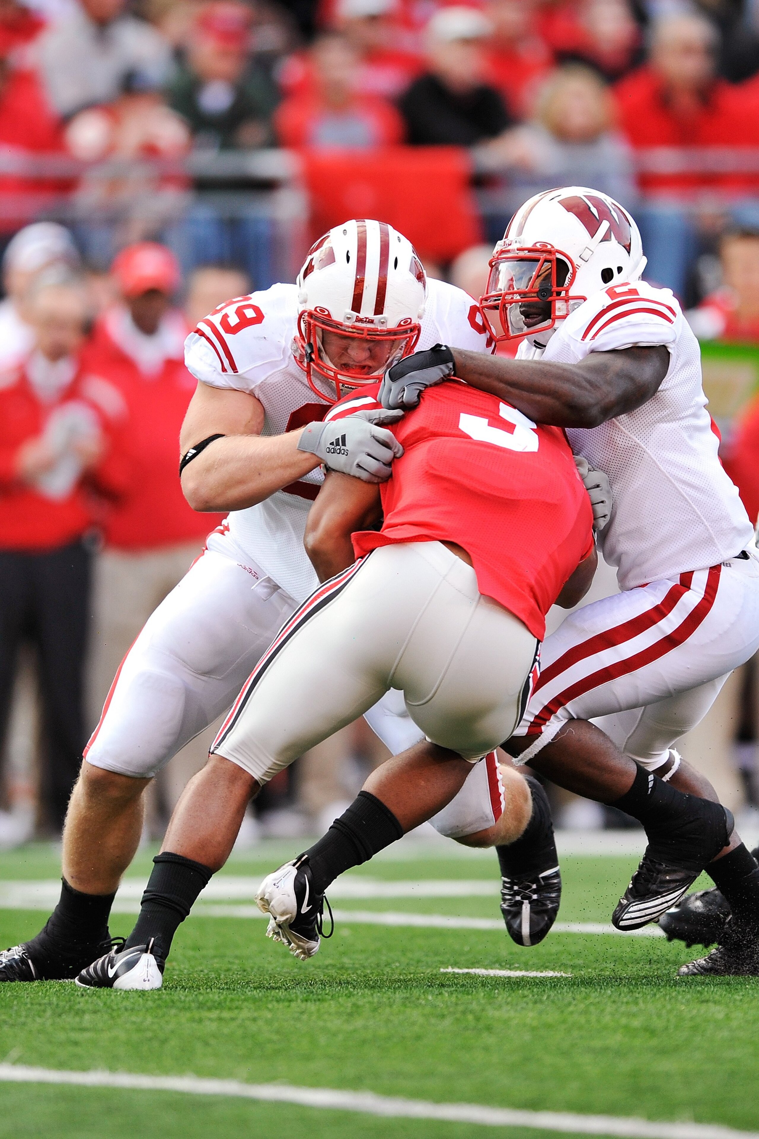 COLUMBUS, OH - OCTOBER 10:  J.J. Watt #99 and Jay Valai #2 of the Wisconsin Badgers make a tackle on Brandon Saine #3 of the Ohio State Buckeyes at Ohio Stadium on October 10, 2009 in Columbus, Ohio.  (Photo by Jamie Sabau/Getty Images)