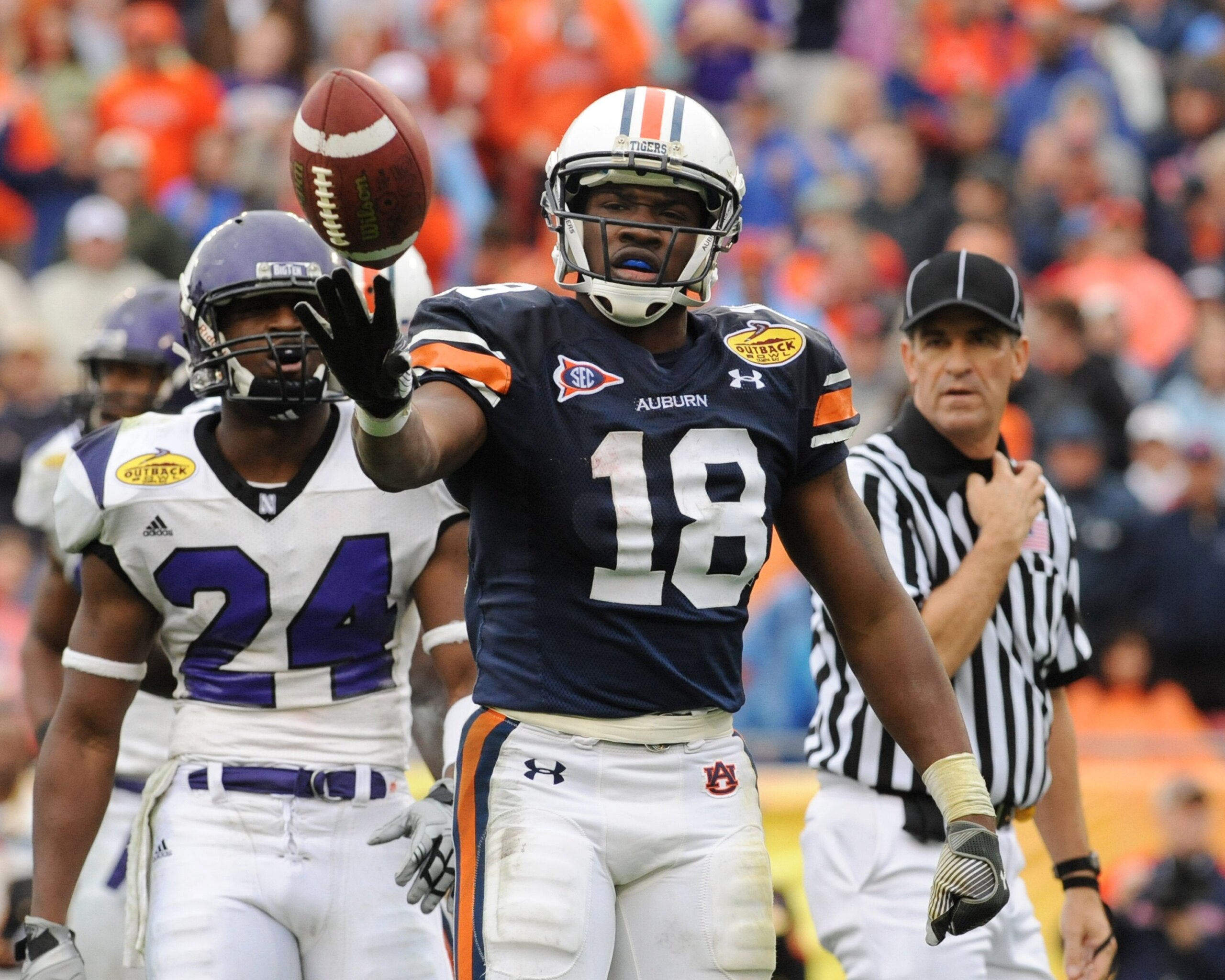 TAMPA, FL - JANUARY 1: Wide receiver Kodi Burns #18 of the Auburn Tigers tosses the football after a kick return against the Northwestern Wildcats in the Outback Bowl January 1, 2010 at Raymond James Stadium in Tampa, Florida.  (Photo by Al Messerschmidt/