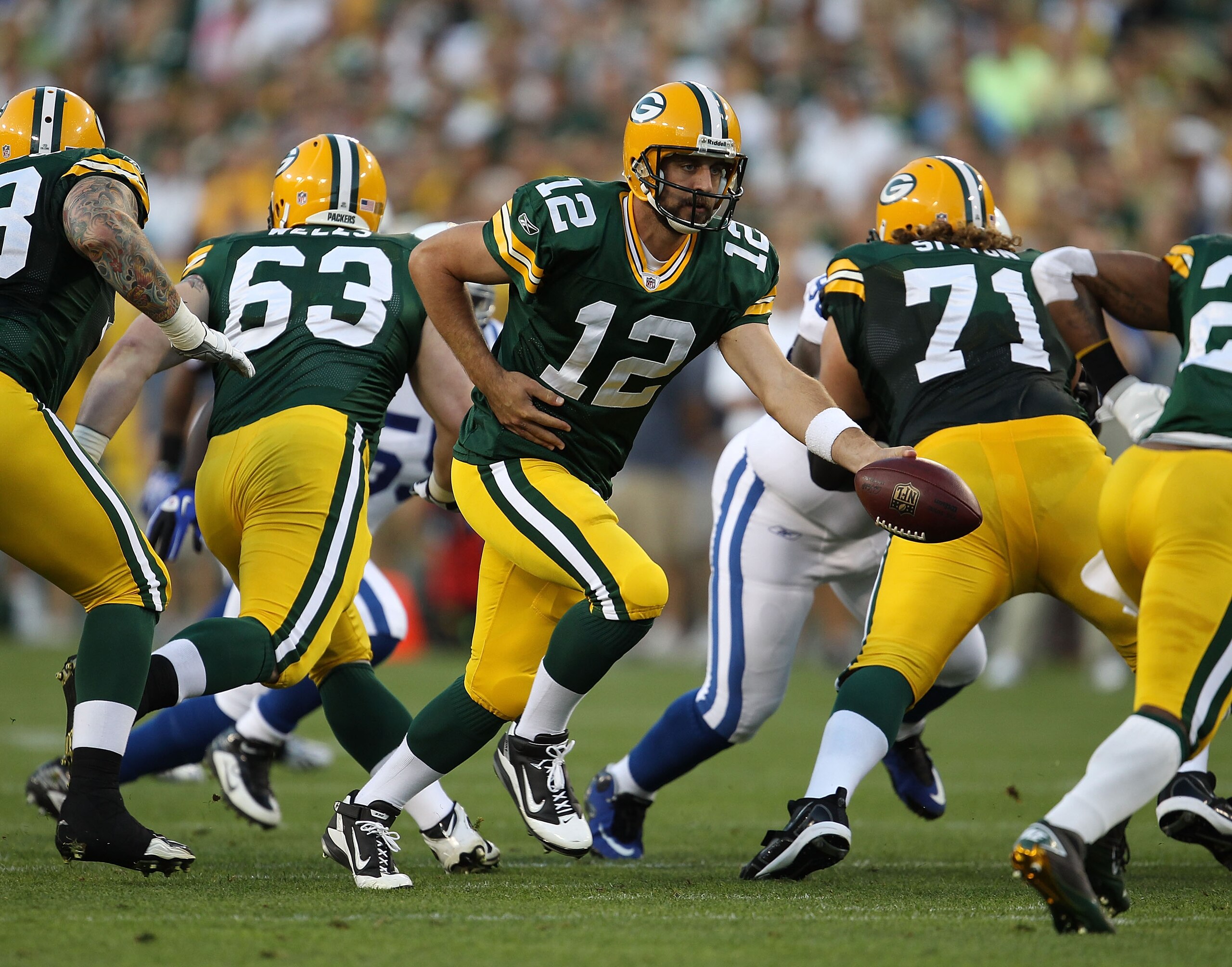 GREEN BAY, WI - AUGUST 26: Aaron Rodgers #12 of the Green Bay Packers turns to hand off against the Indianapolis Colts during a preseason game at Lambeau Field on August 26, 2010 in Green Bay, Wisconsin. The Packers defeated the Colts 59-24.  (Photo by Jo