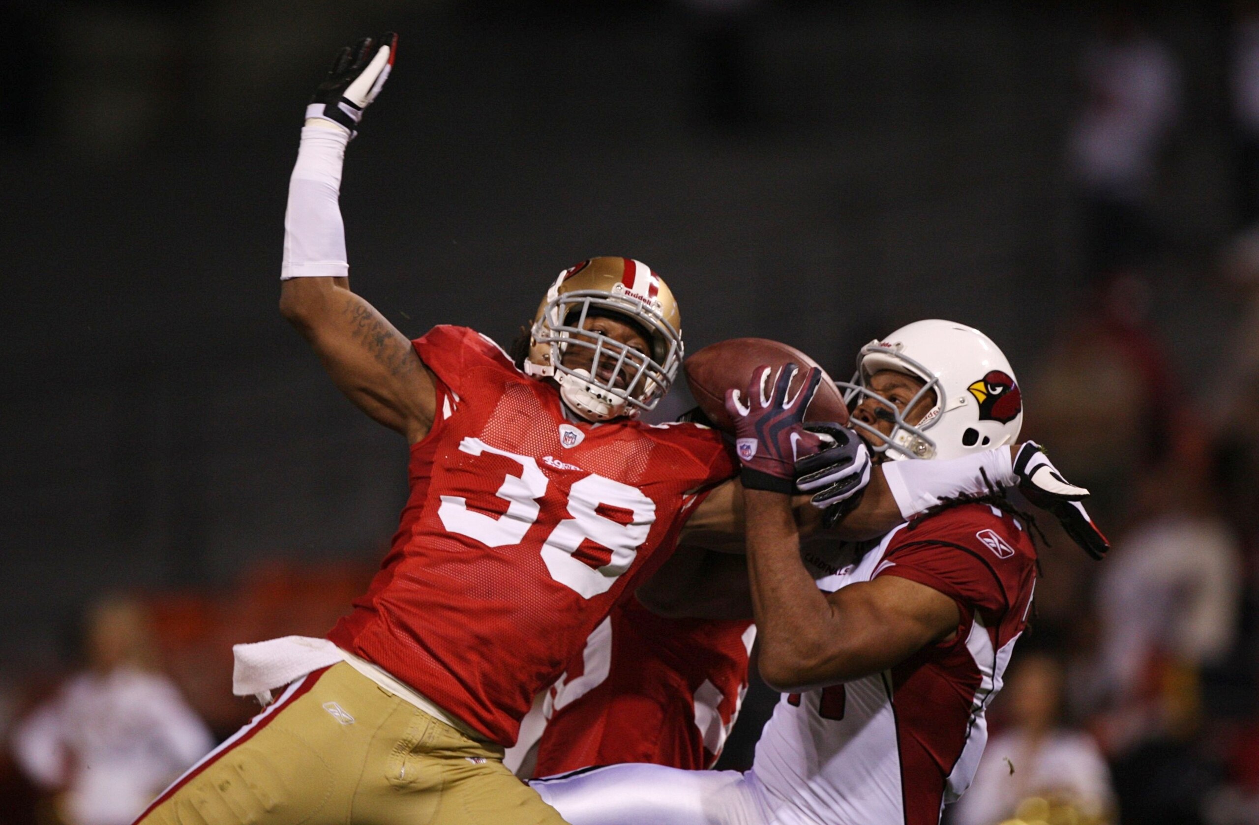 SAN FRANCISCO - DECEMBER 14:  Wide receiver Larry Fitzgerald #11 of the Arizona Cardinals goes up for a catch as it is broken up by Dashon Goldson #38 of the San Francisco 49ers in the first half at Candlestick Park on December 14, 2009 in San Francisco,
