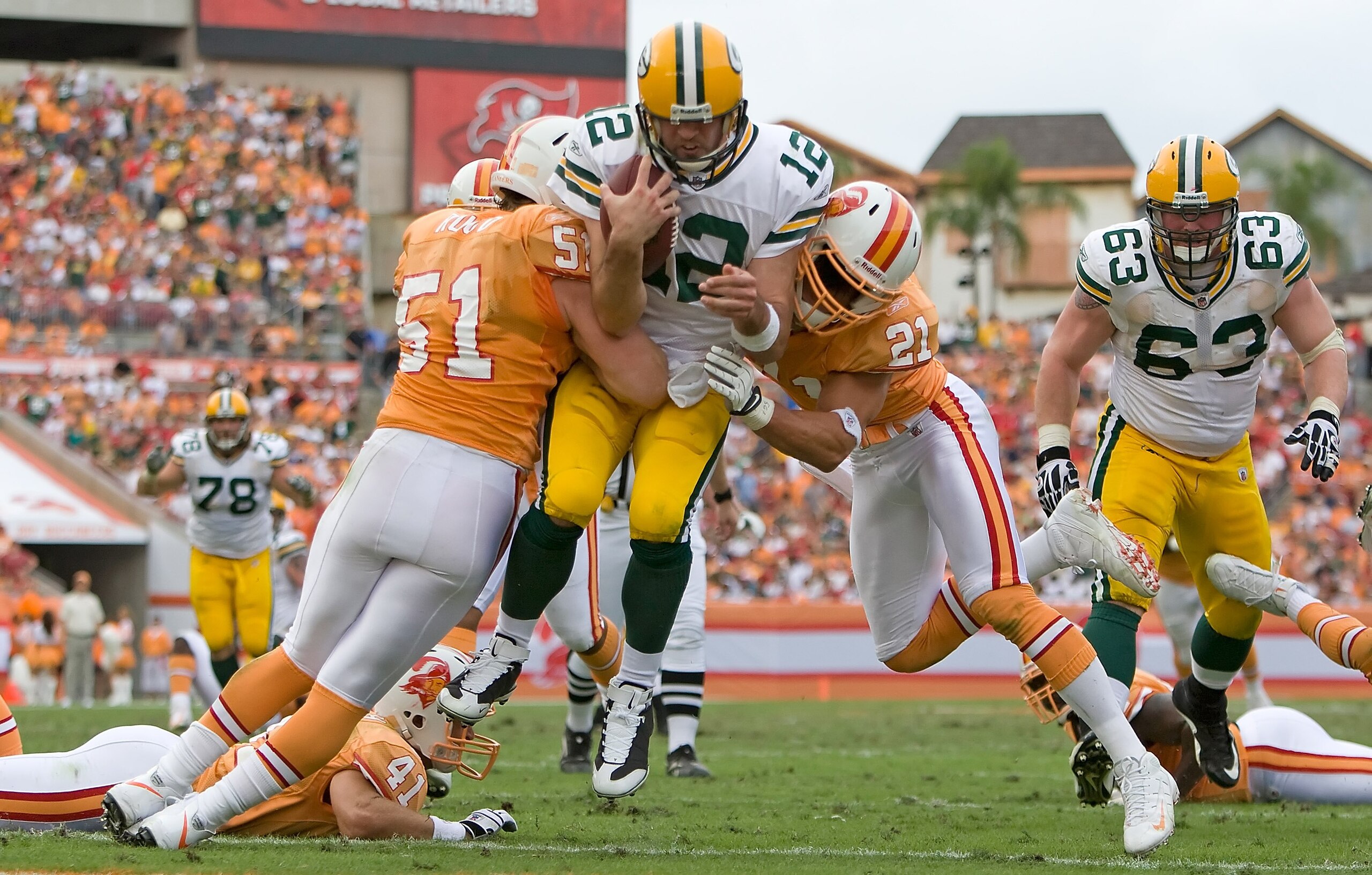 TAMPA, FL - NOVEMBER 08:  Quarterback Aaron Rodgers #12 of the Green Bay Packers scores a fourth quarter touchdown as defenders Barrett Ruud #51 and Sabby Piscatelli #21 of the Tampa Bay Buccaneers deliver a hit during the game at Raymond James Stadium on