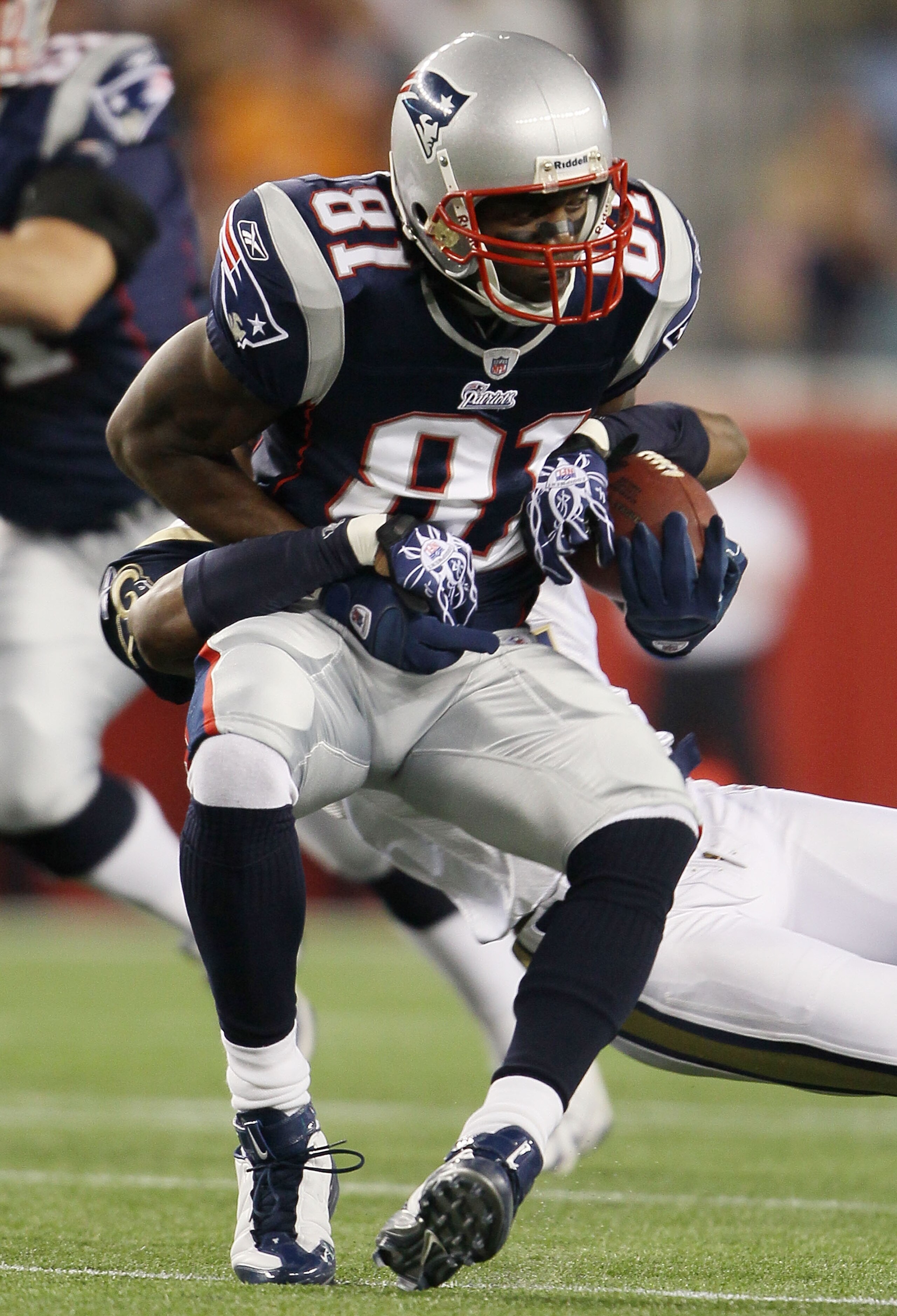 FOXBORO, MA - AUGUST 26:  Randy Moss #81 of the New England Patriots hangs on to the catch as he is tackled by a member of the St. Louis Rams on August 26, 2010 at Gillette Stadium in Foxboro, Massachusetts.  (Photo by Elsa/Getty Images)