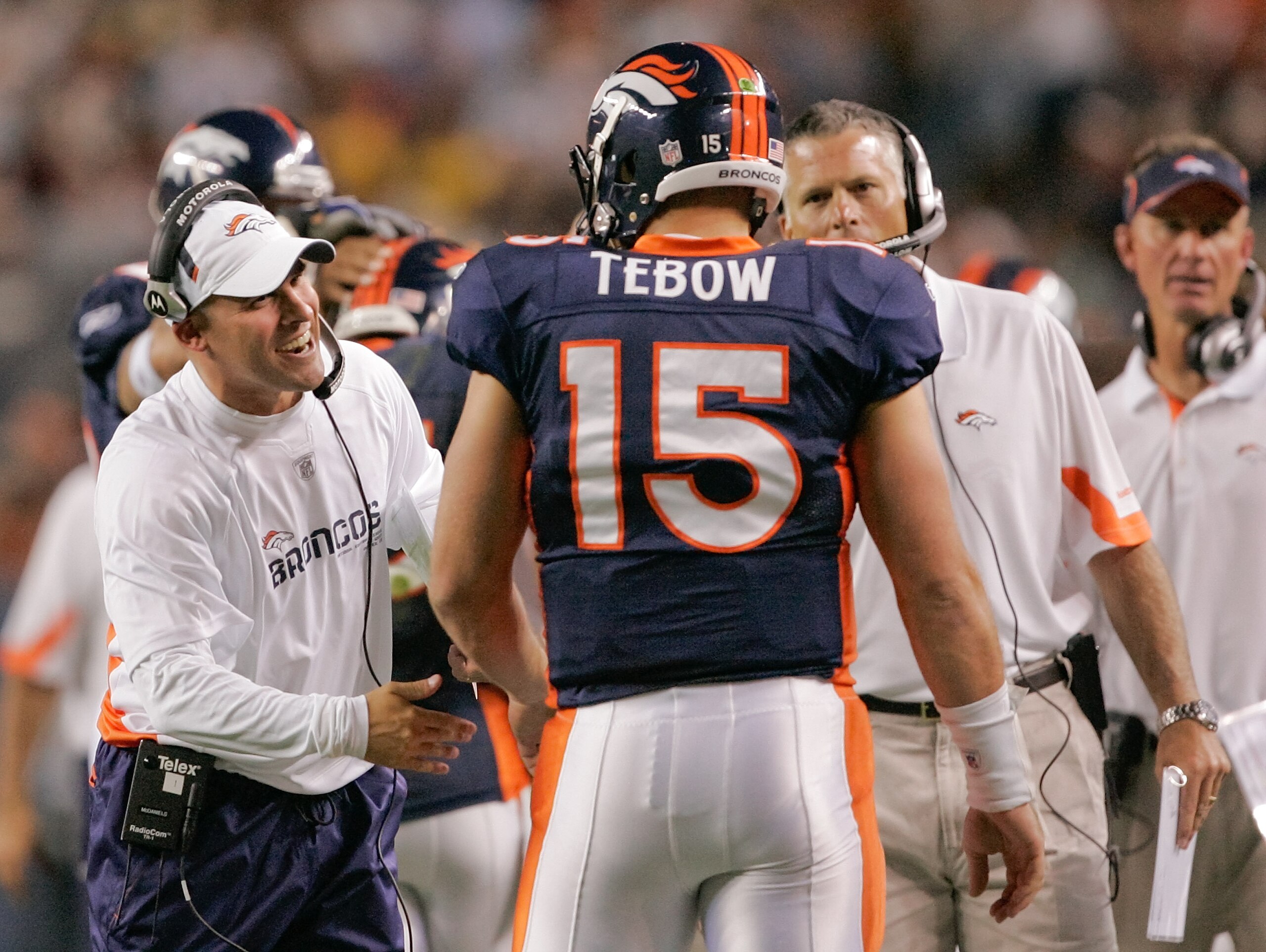 DENVER - AUGUST 29: Head coach Josh McDaniels of the Denver Broncos congratulates quarterback Tim Tebow #15 following his fourth quarter touchdown pass against the Pittsburgh Steelers at INVESCO Field at Mile High on August 29, 2010 in Denver, Colorado.  
