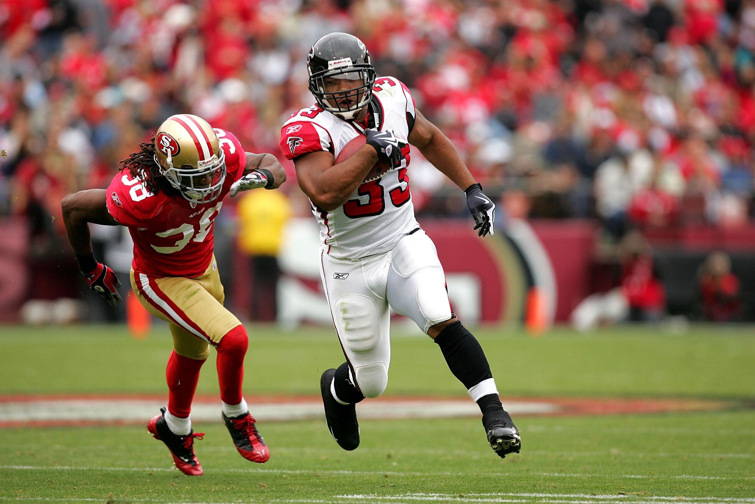 SAN FRANCISCO - OCTOBER 11:  Michael Turner #33 of the Atlanta Falcons runs past Dashon Goldson #38 of the San Francisco 49ers at Candlestick Park on October 11, 2009 in San Francisco, California.  (Photo by Ezra Shaw/Getty Images)