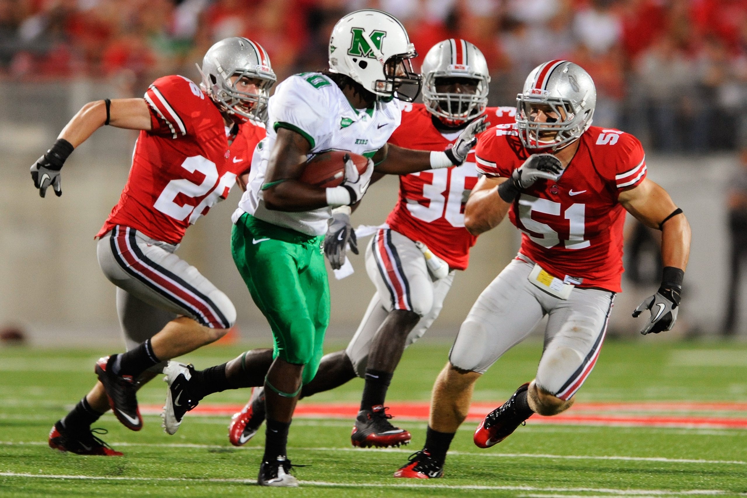 COLUMBUS, OH - SEPTEMBER 2:  Tyler Moeller #26, Brian Rolle #36 and Ross Homan #5 of the Ohio State Buckeyes pursue Courtney Edmonson #80 of the Marshall Thundering Herd  at Ohio Stadium on September 2, 2010 in Columbus, Ohio.  (Photo by Jamie Sabau/Getty