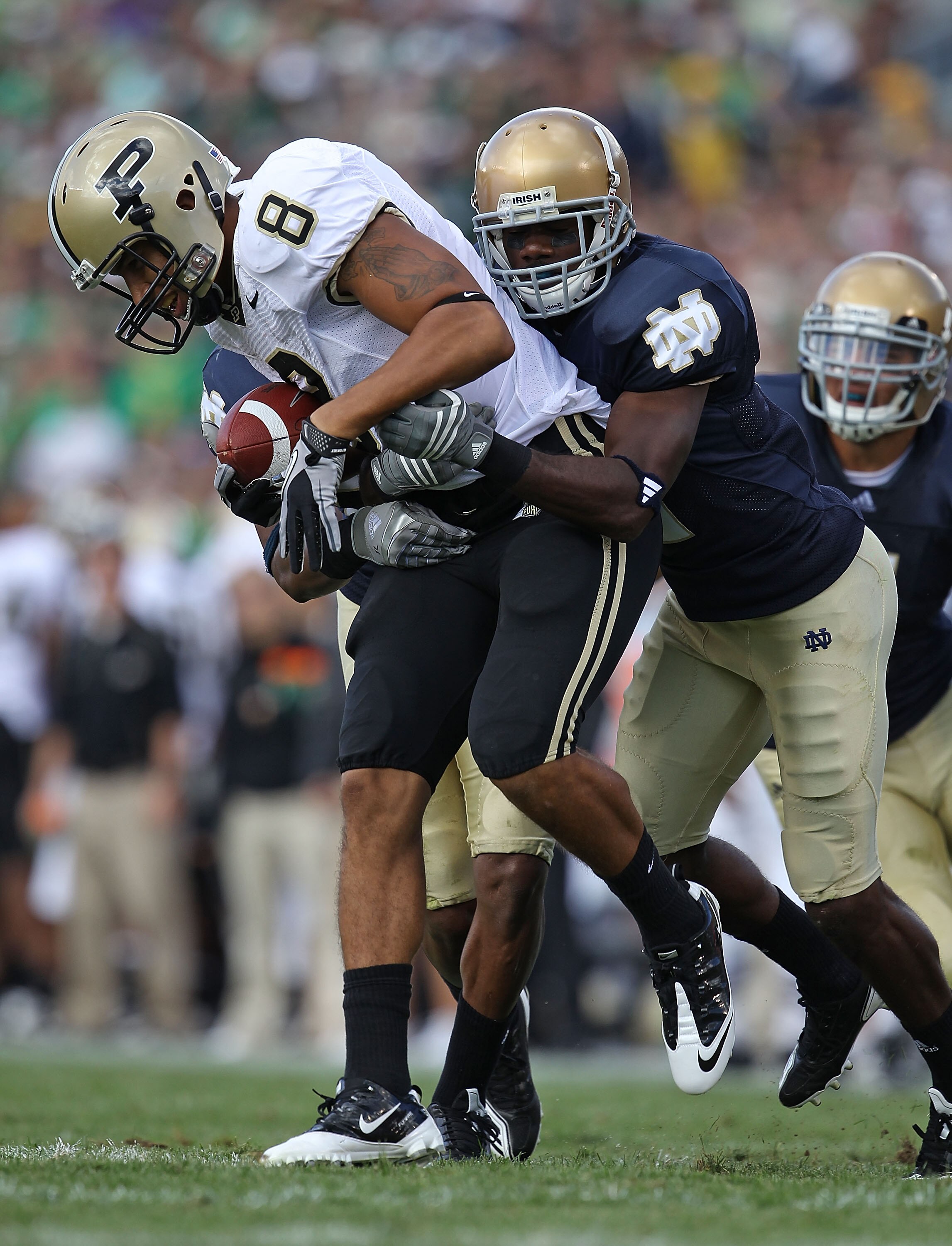 SOUTH BEND, IN - SEPTEMBER 04: Keith Smith #8 of the Purdue Boilermakers is stopped by Darrin Walls #2 (R) and Jamoris Slaughter #26 of the Notre Dame Fighting Irish at Notre Dame Stadium on September 4, 2010 in South Bend, Indiana. (Photo by Jonathan Dan
