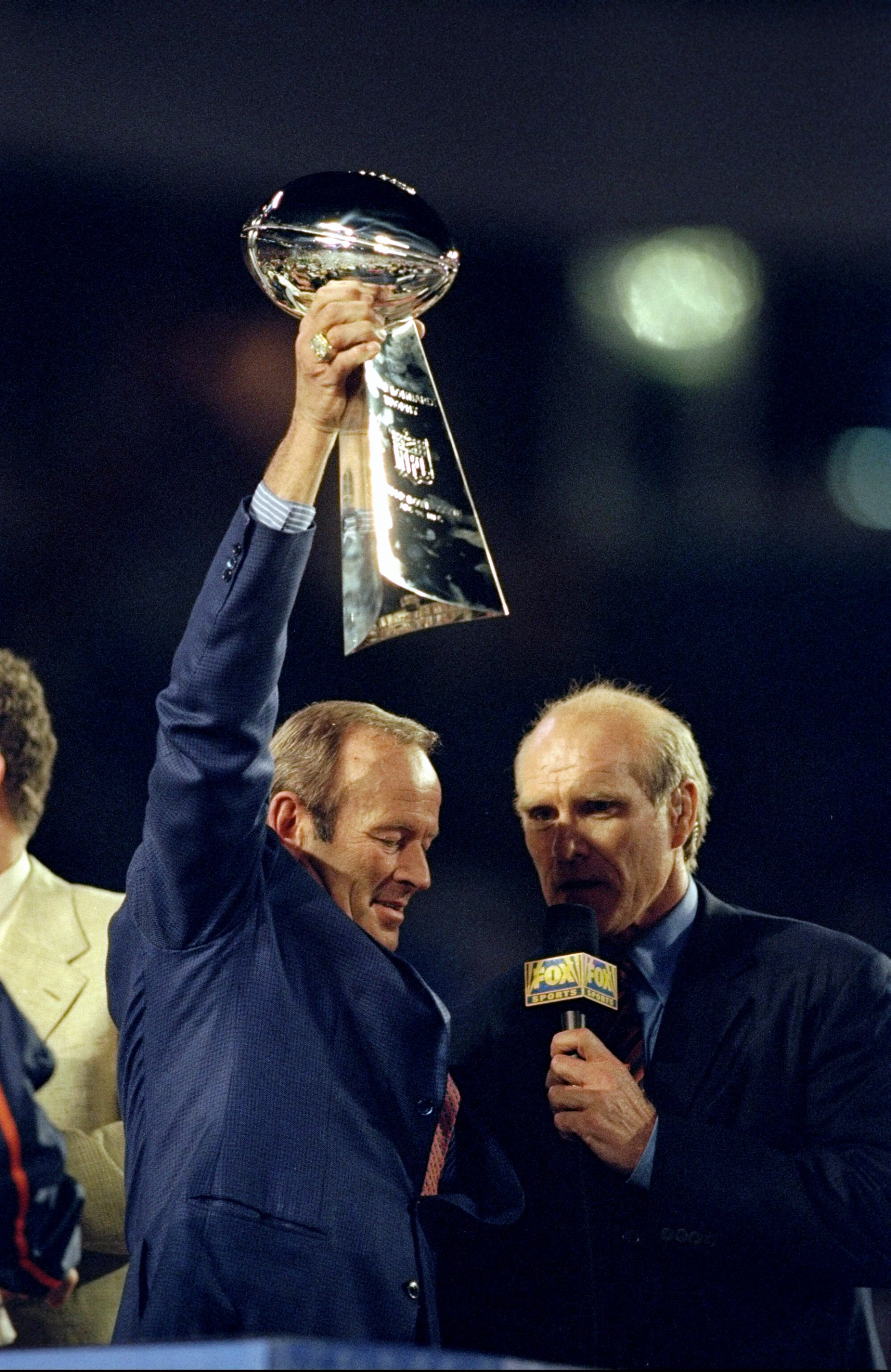 31 Jan 1999: Fox Sports TV analyst Terry Bradshaw interviews owner Pat Bowlen of the Denver Broncos as he holds up the Vince Lombardi trophy after the Broncos defeated the Atlanta Falcons to win Super Bowl XXXIII at Pro Player Stadium in Miami, Florida. T