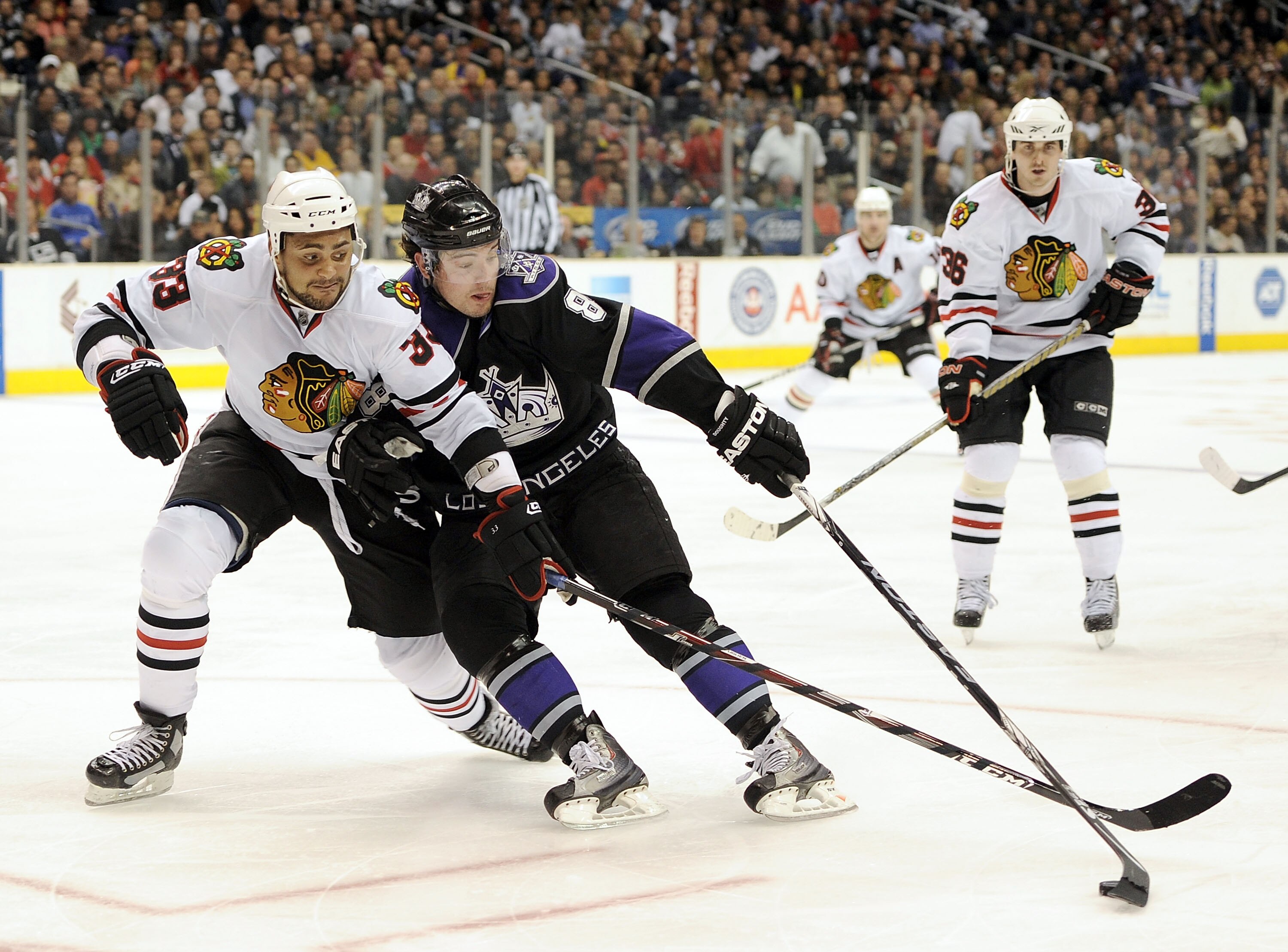 LOS ANGELES, CA - MARCH 18:  Drew Doughty #8 of the Los Angeles Kings gets attempts to get around Dustin Byfuglien #33 and Dave Bolland #36 of the Chicago Blackhawks during the second period at the Staples Center on March 18, 2010 in Los Angeles, Californ